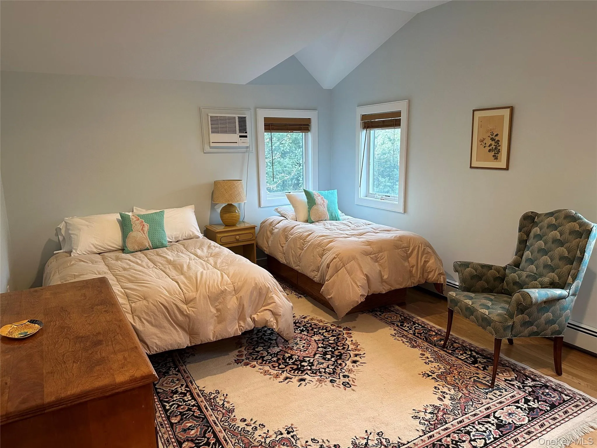 Bedroom featuring lofted ceiling, wood finished floors, and a wall mounted AC Bedroom featuring lofted ceiling, wood finished floors, and a wall mounted AC