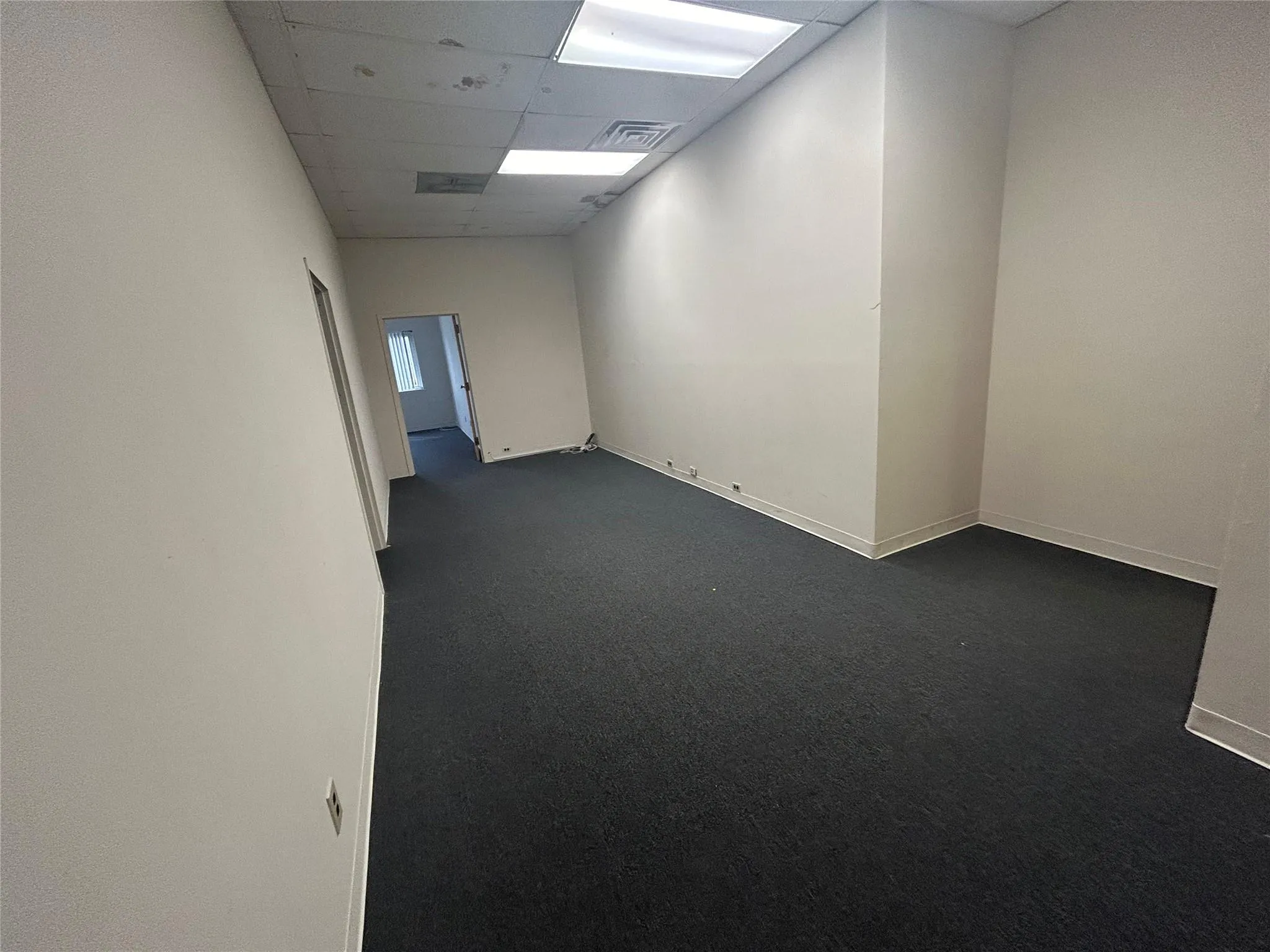 Unfurnished room with visible vents, dark carpet, a paneled ceiling, and baseboards Unfurnished room with visible vents, dark carpet, a paneled ceiling, and baseboards