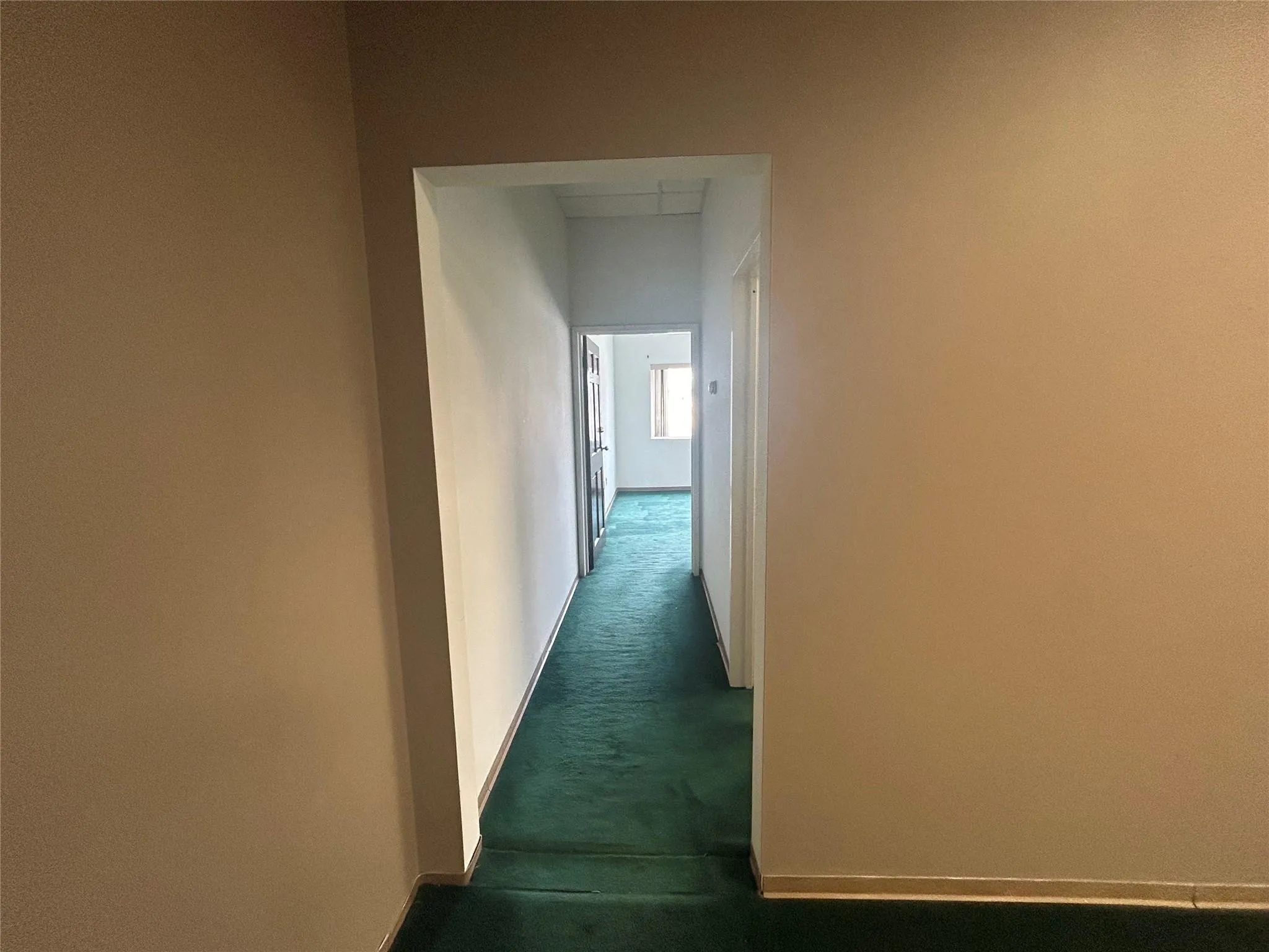 Corridor with baseboards and dark carpet Corridor with baseboards and dark carpet