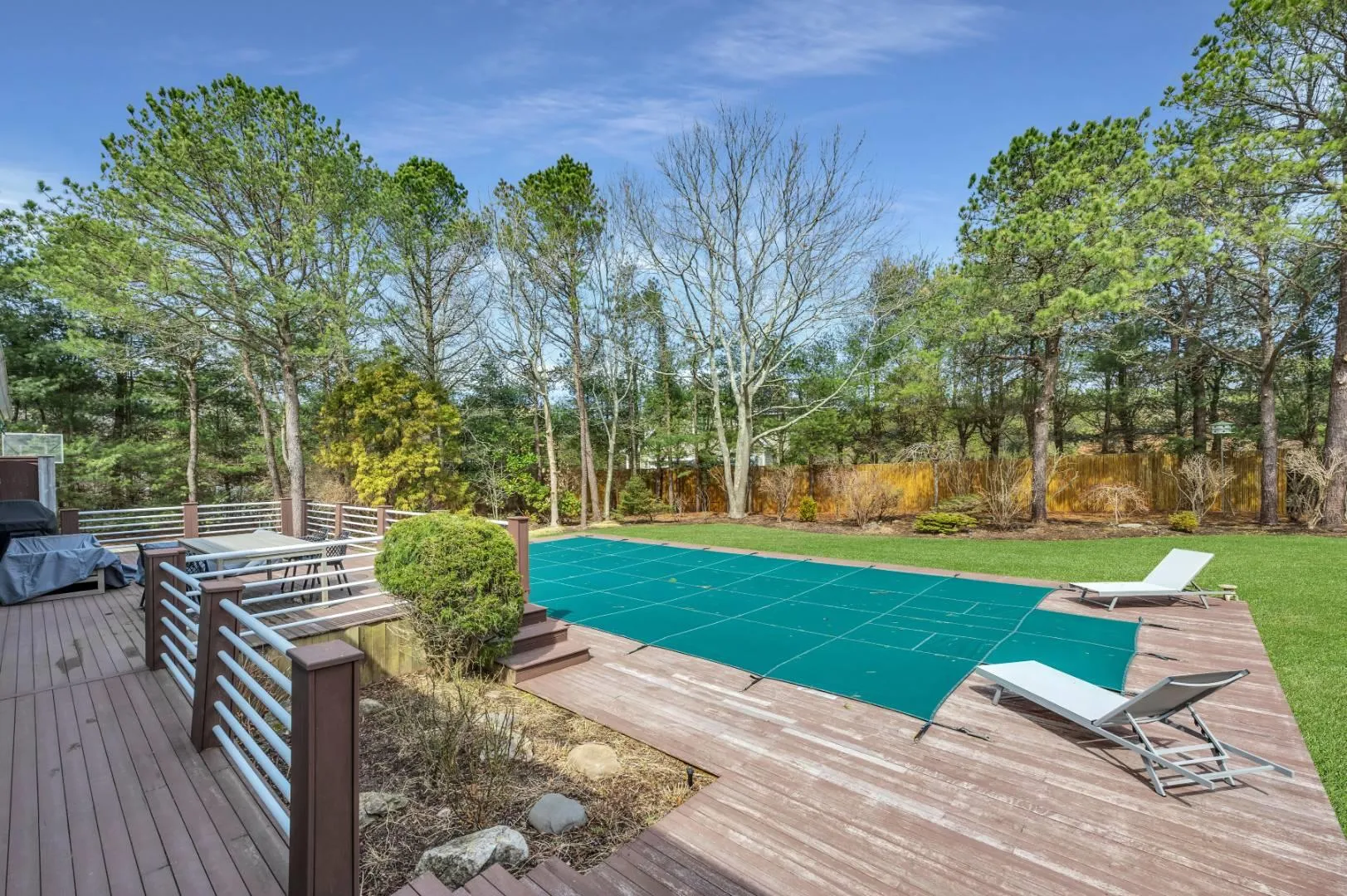 View of pool with a yard, a fenced backyard, and a wooden deck View of pool with a yard, a fenced backyard, and a wooden deck