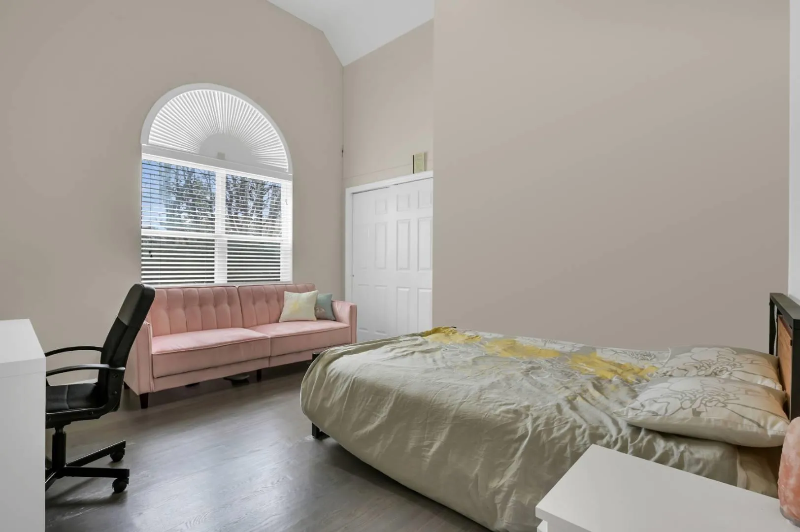 Bedroom with high vaulted ceiling and wood finished floors Bedroom with high vaulted ceiling and wood finished floors