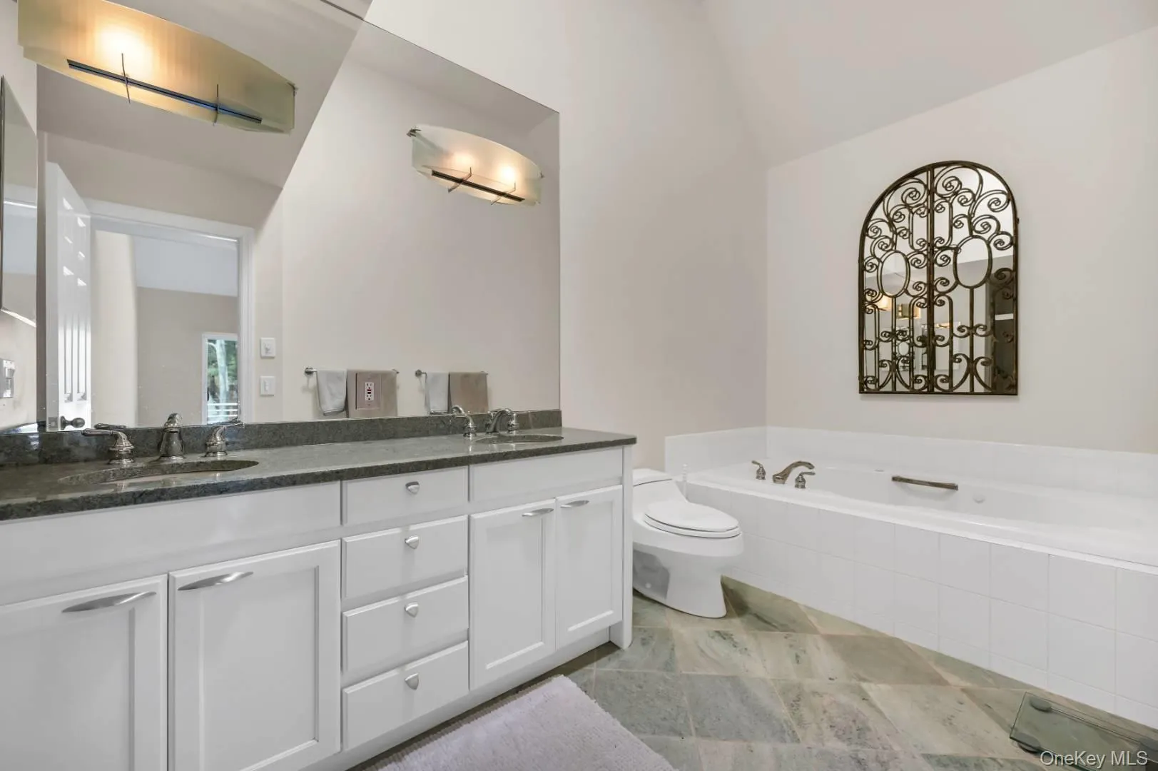 Bathroom with a garden tub, double vanity, a sink, and toilet Bathroom with a garden tub, double vanity, a sink, and toilet