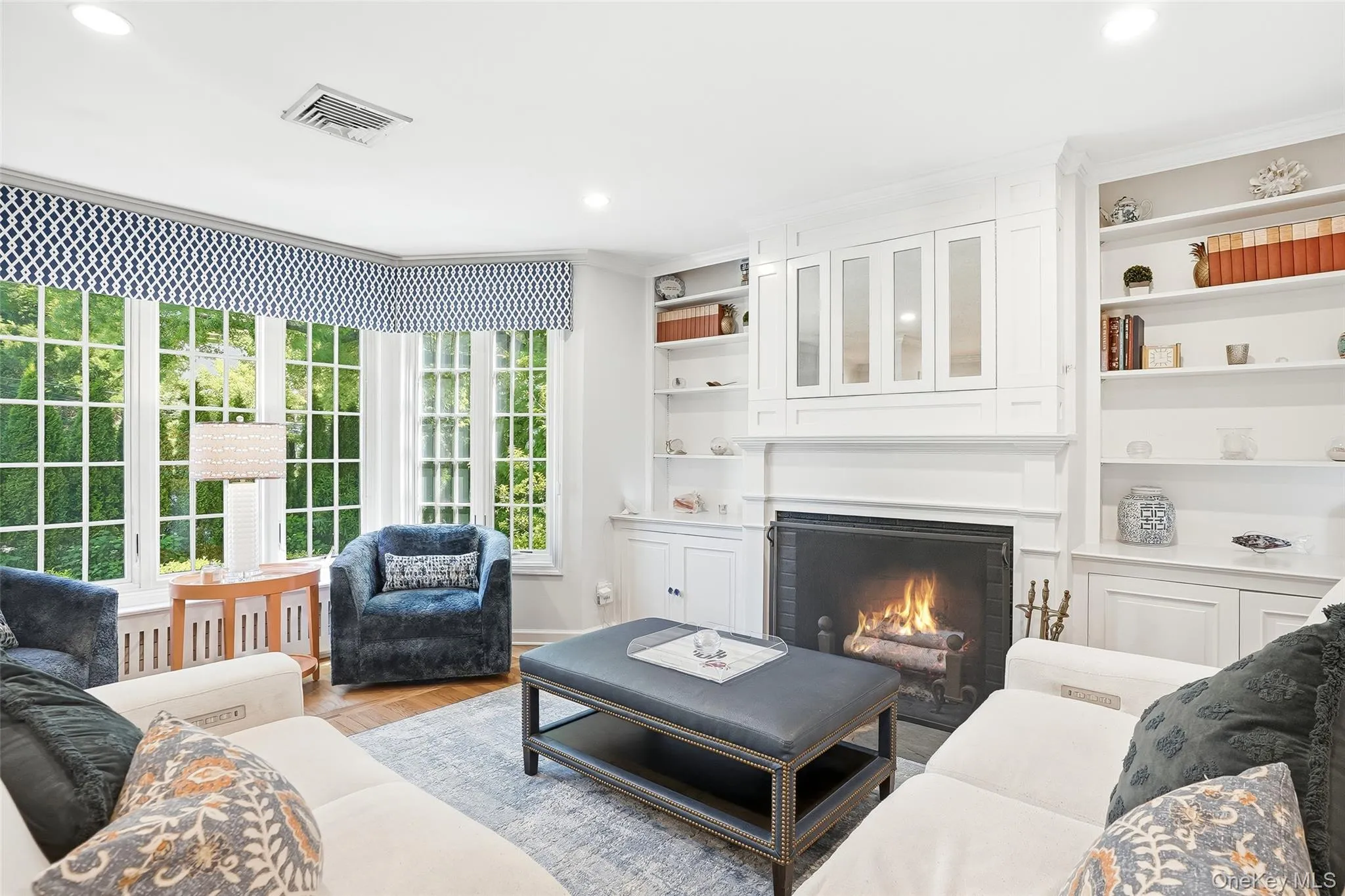 Living Room features custom built-ins (yes, there is a TV hiding behind that cabinet over the fireplace) and a wall of windows Living Room features custom built-ins (yes, there is a TV hiding behind that cabinet over the fireplace) and a wall of windows