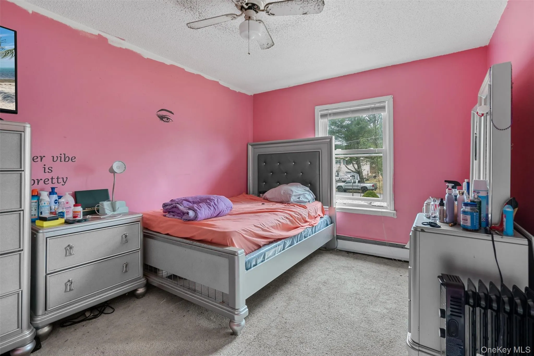 Bedroom featuring light carpet, baseboard heating, a ceiling fan, and a textured ceiling Bedroom featuring light carpet, baseboard heating, a ceiling fan, and a textured ceiling