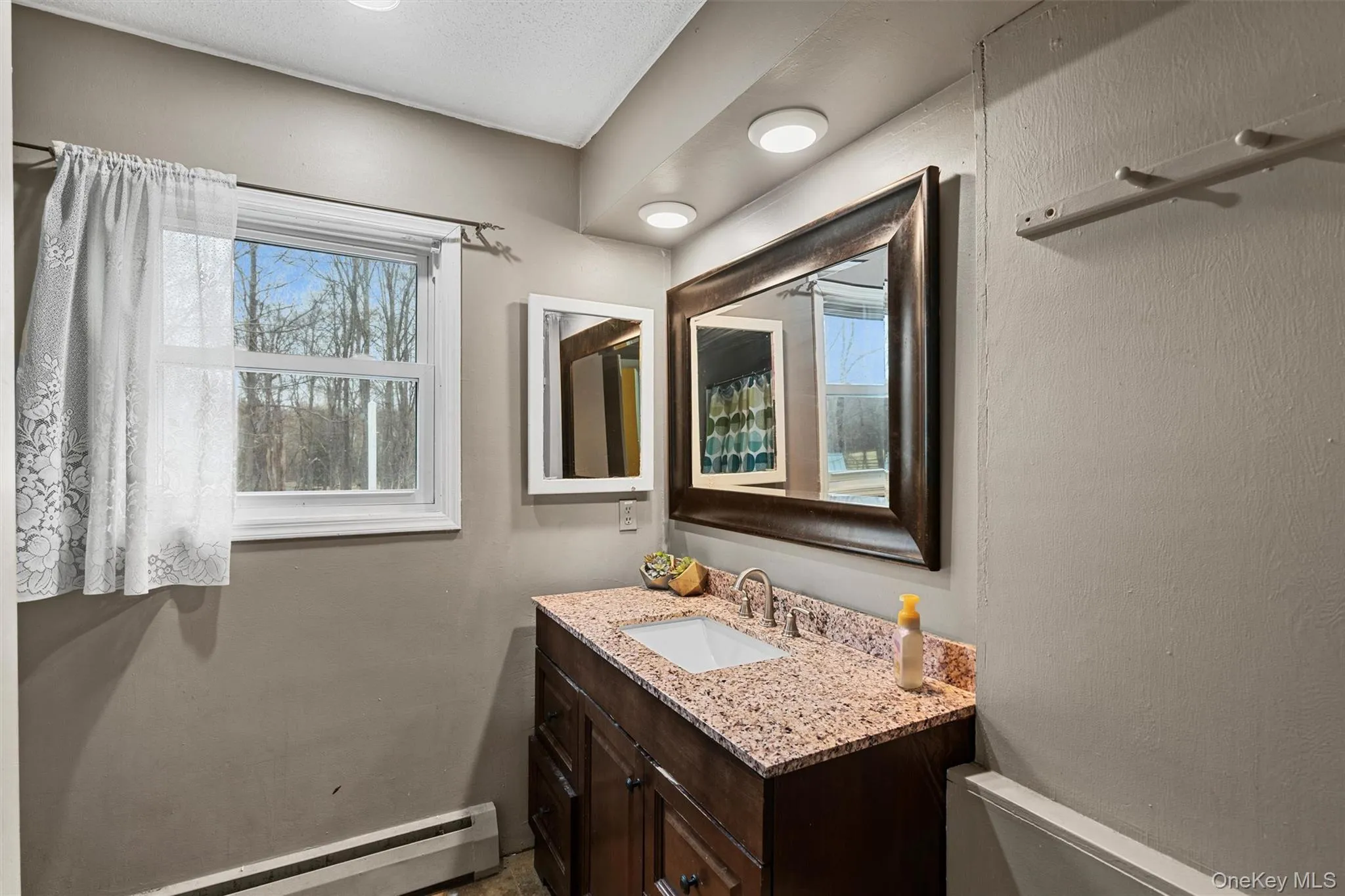 Bathroom featuring vanity and a baseboard heating unit Bathroom featuring vanity and a baseboard heating unit