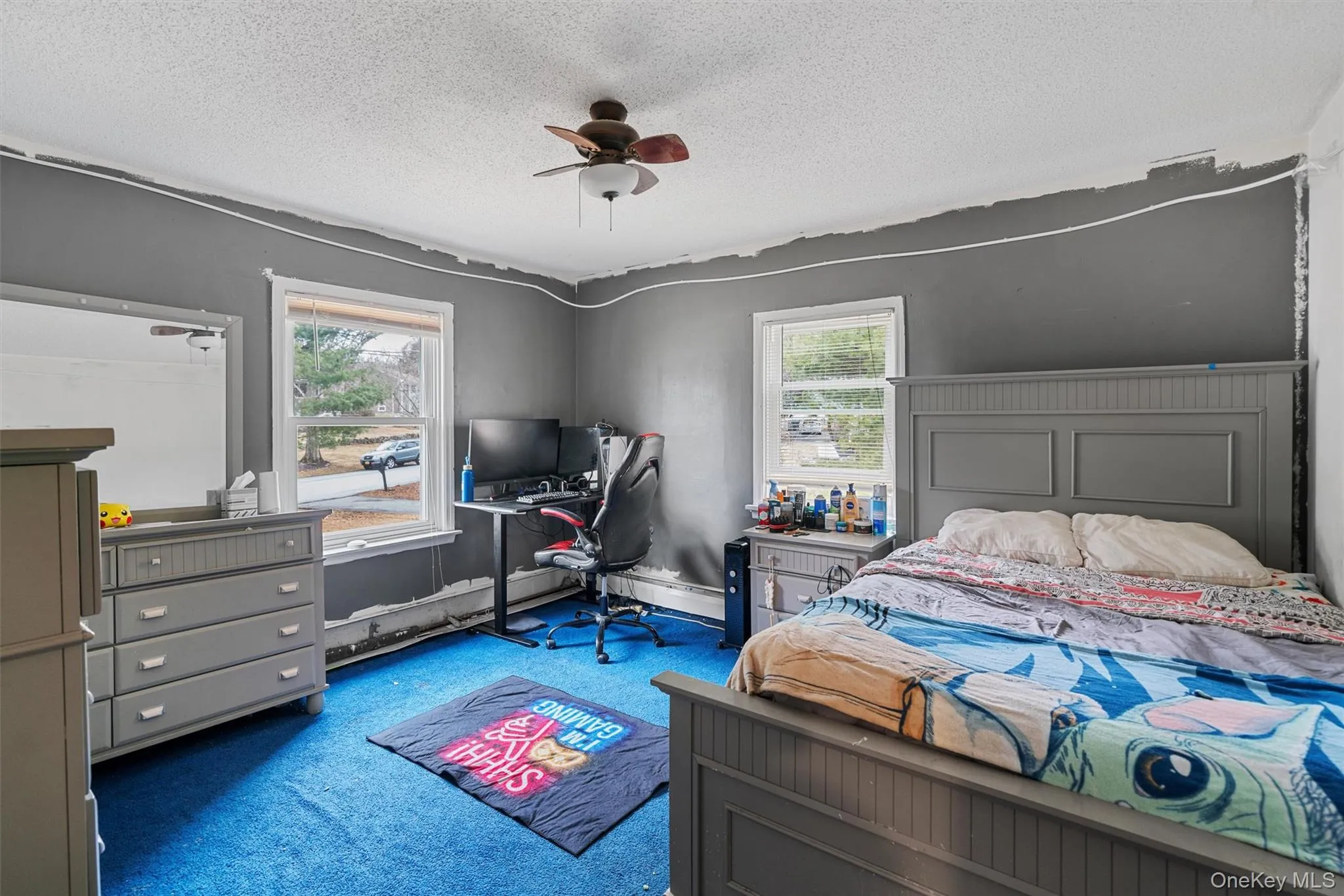 Bedroom with baseboards, a textured ceiling, carpet, and a ceiling fan Bedroom with baseboards, a textured ceiling, carpet, and a ceiling fan
