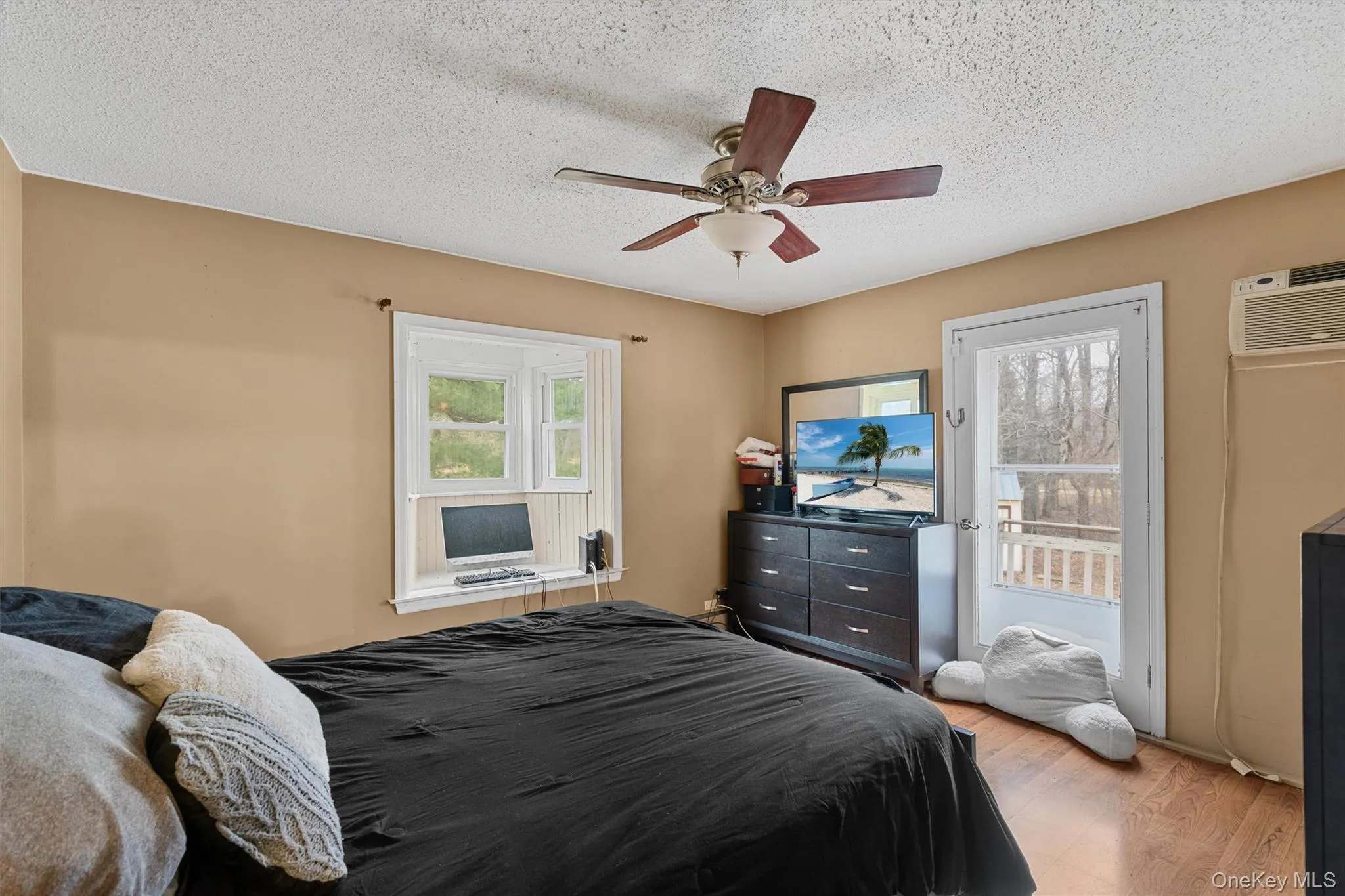 Bedroom featuring light wood-type flooring, a textured ceiling, a ceiling fan, and access to outside Bedroom featuring light wood-type flooring, a textured ceiling, a ceiling fan, and access to outside