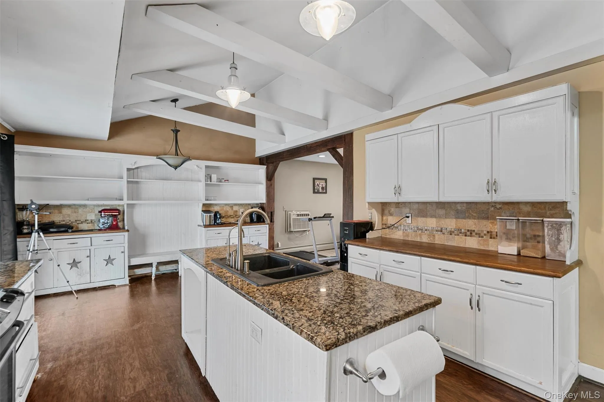 Kitchen featuring a sink, open shelves, lofted ceiling with beams, dark wood finished floors, and white cabinets Kitchen featuring a sink, open shelves, lofted ceiling with beams, dark wood finished floors, and white cabinets