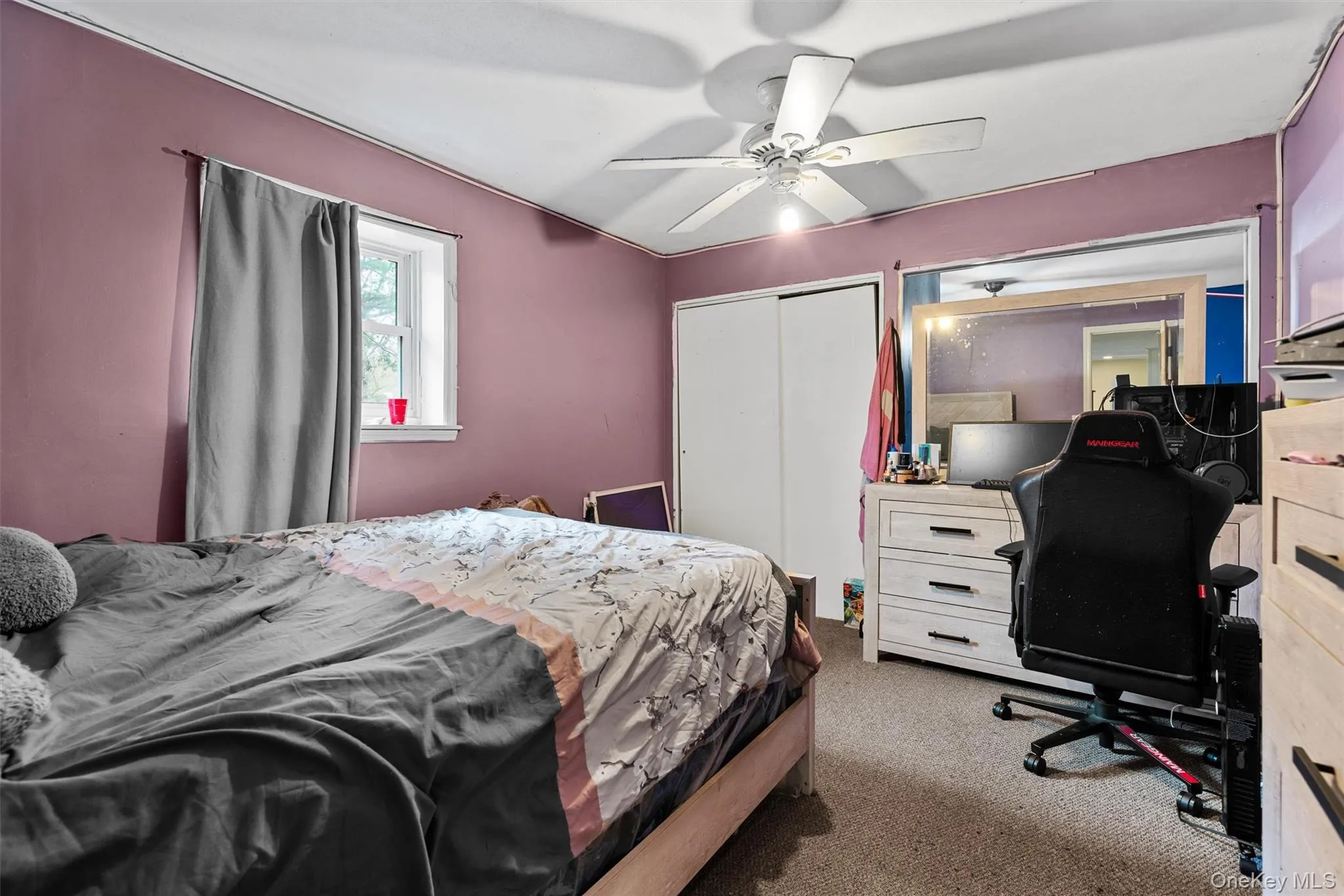 Carpeted bedroom with a closet and ceiling fan Carpeted bedroom with a closet and ceiling fan