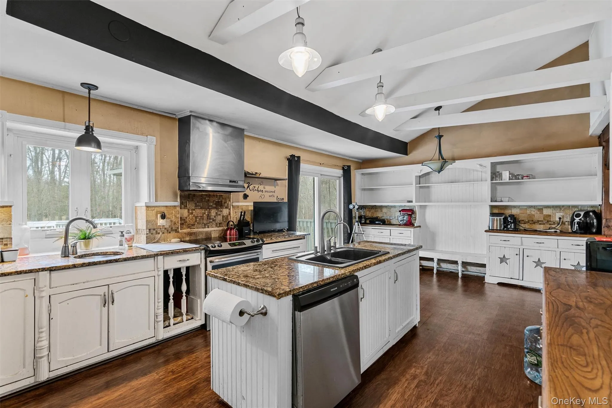 Kitchen with open shelves, stainless steel appliances, a sink, and wall chimney range hood Kitchen with open shelves, stainless steel appliances, a sink, and wall chimney range hood