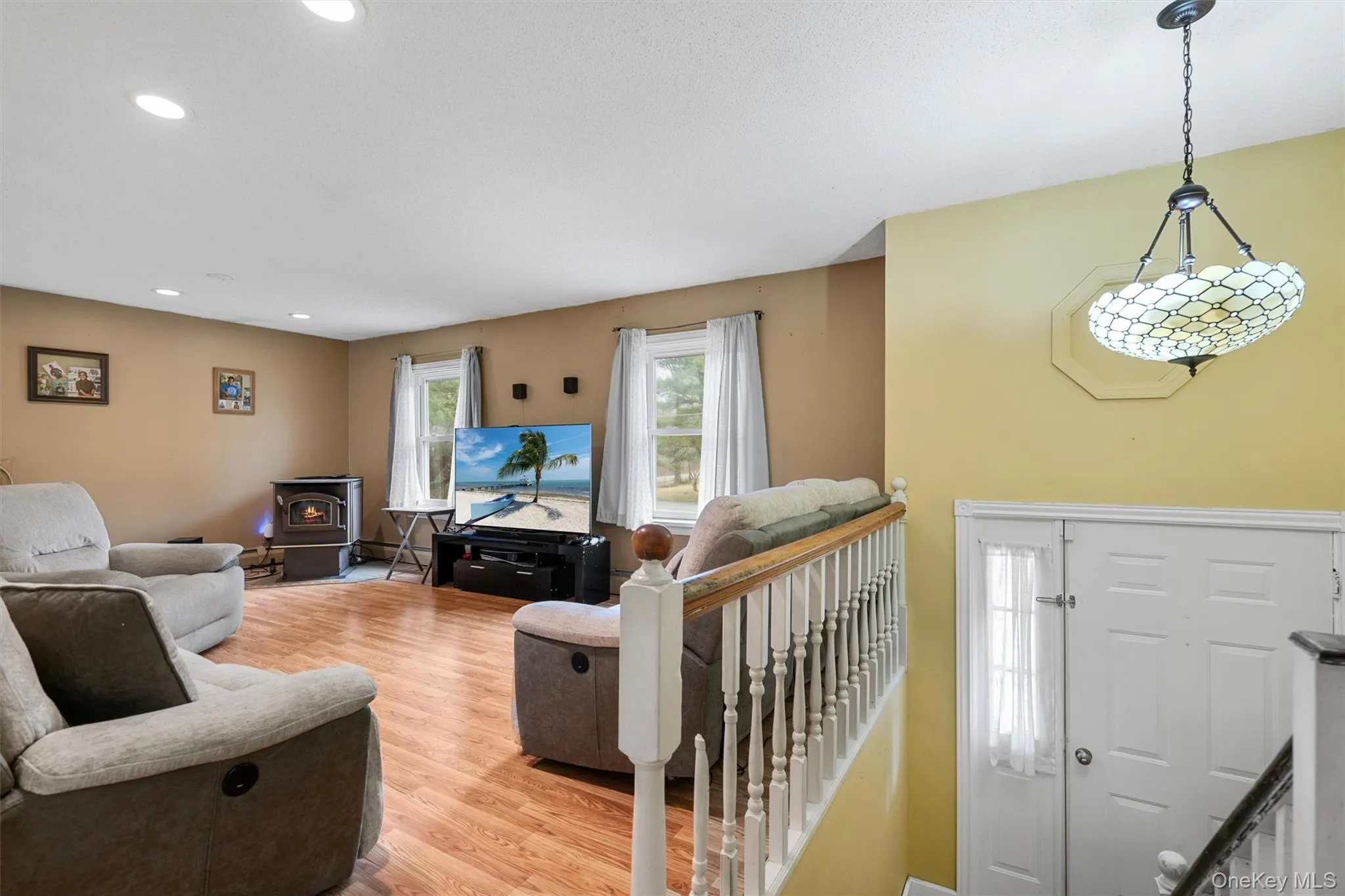 Living room with a wood stove, recessed lighting, and light wood-style floors Living room with a wood stove, recessed lighting, and light wood-style floors