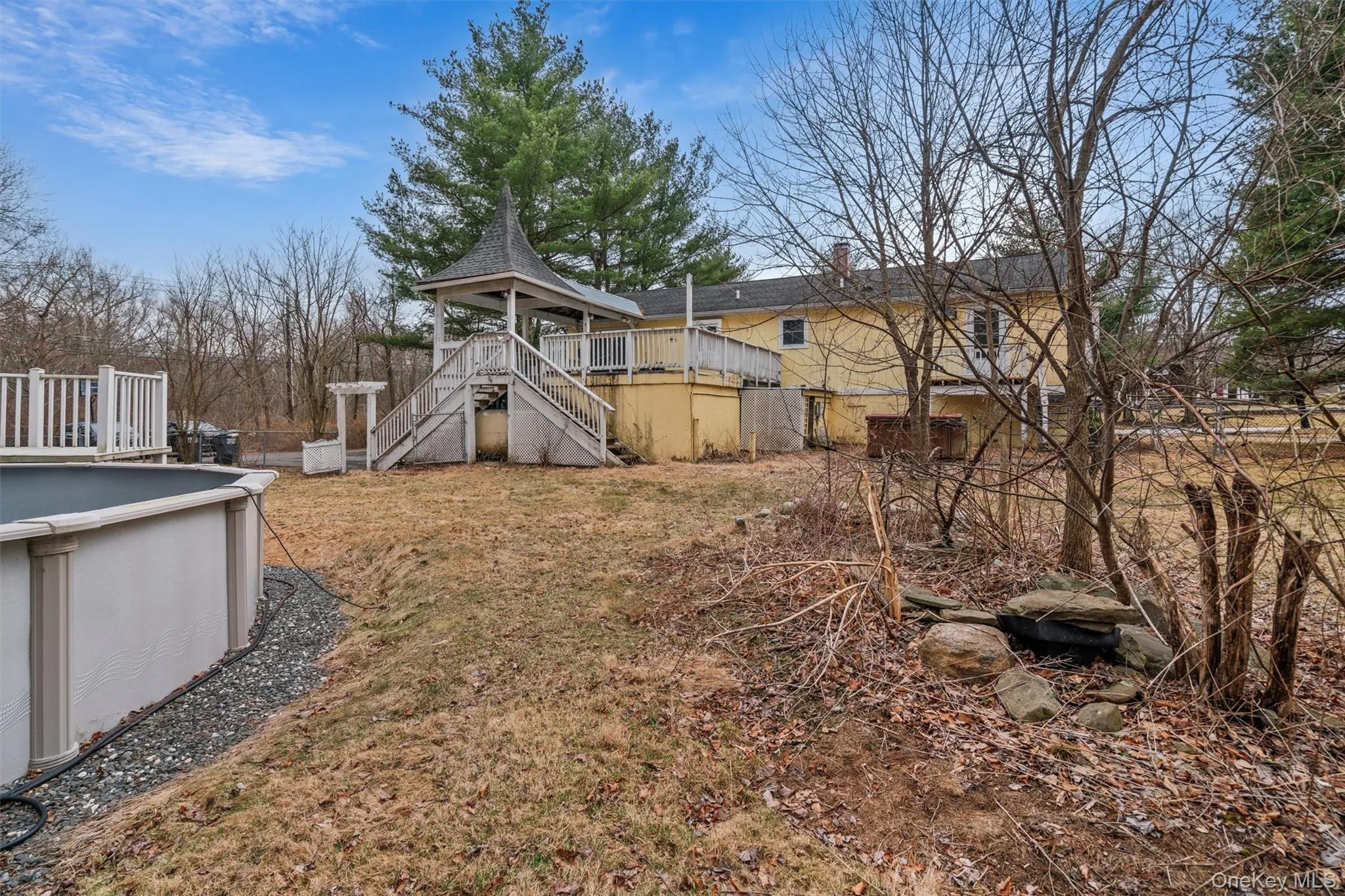 View of yard with an outdoor pool, a deck, stairs, and fence View of yard with an outdoor pool, a deck, stairs, and fence