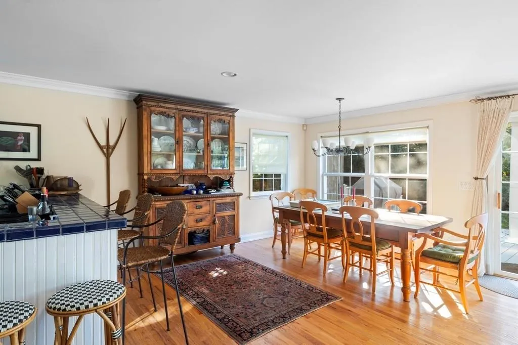 Dining space featuring light wood-style flooring, a notable chandelier, baseboards, ornamental molding, and radiator Dining space featuring light wood-style flooring, a notable chandelier, baseboards, ornamental molding, and radiator
