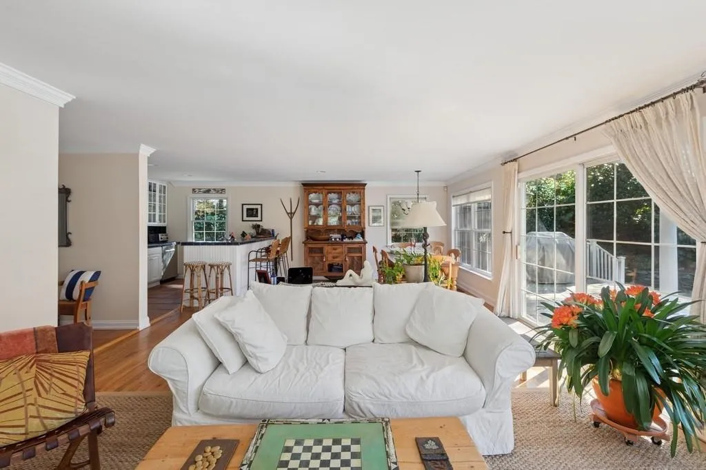 Living area featuring ornamental molding, wood finished floors, and baseboards Living area featuring ornamental molding, wood finished floors, and baseboards