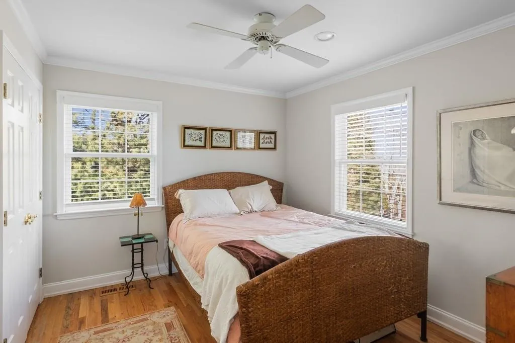 Bedroom featuring baseboards, wood finished floors, a ceiling fan, and crown molding Bedroom featuring baseboards, wood finished floors, a ceiling fan, and crown molding