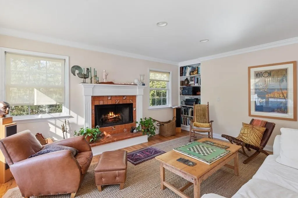 Living area with ornamental molding, wood finished floors, and a tile fireplace Living area with ornamental molding, wood finished floors, and a tile fireplace