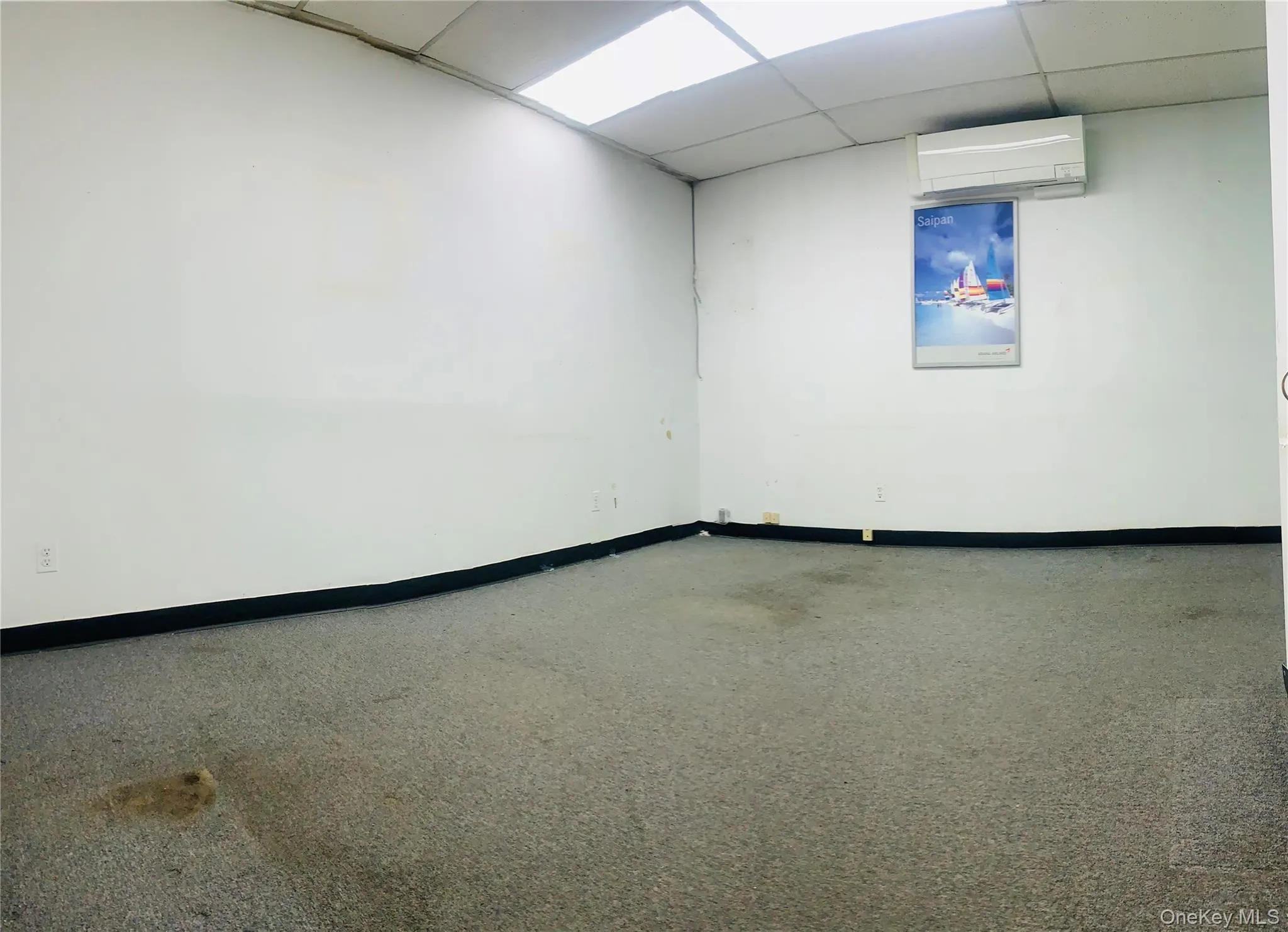 Spare room with a paneled ceiling, baseboards, and a wall mounted AC Spare room with a paneled ceiling, baseboards, and a wall mounted AC