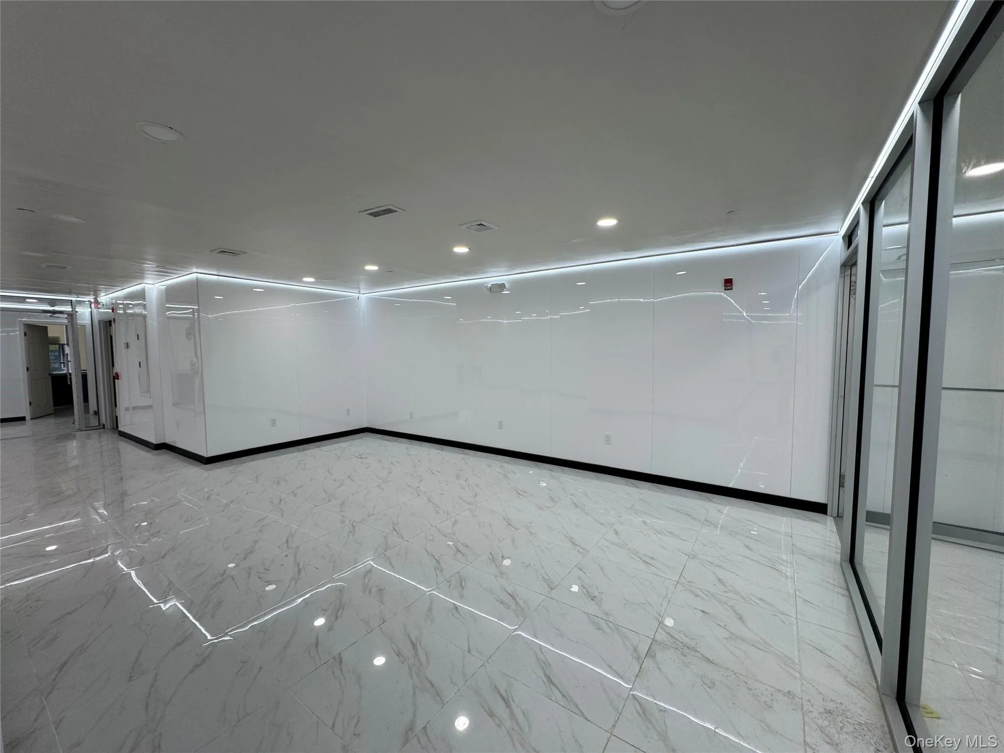 Unfurnished room featuring marble finish floor and visible vents Unfurnished room featuring marble finish floor and visible vents