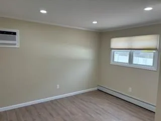 Spare room with a baseboard radiator, recessed lighting, baseboards, and wood finished floors Spare room with a baseboard radiator, recessed lighting, baseboards, and wood finished floors