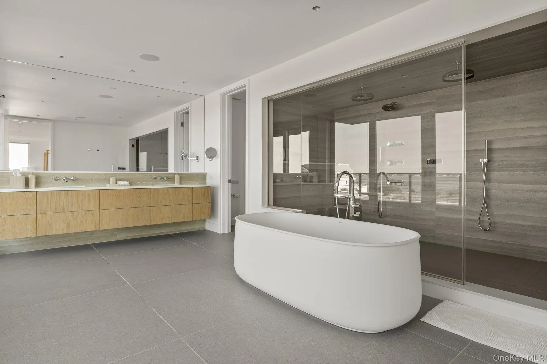 Bathroom featuring a shower stall, double vanity, a soaking tub, and tile patterned floors Bathroom featuring a shower stall, double vanity, a soaking tub, and tile patterned floors