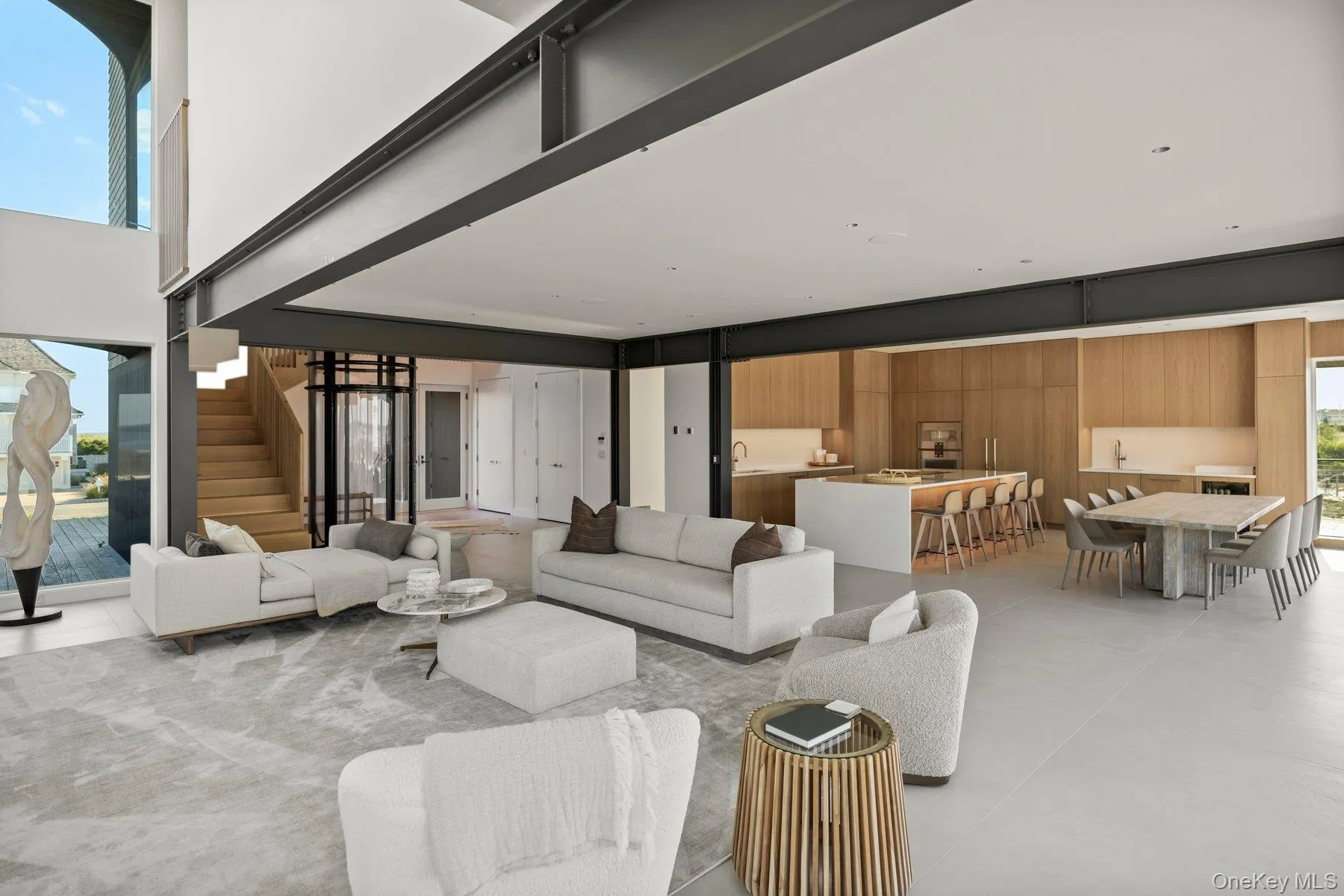 Living room with stairway, a high ceiling, and tile patterned floors Living room with stairway, a high ceiling, and tile patterned floors