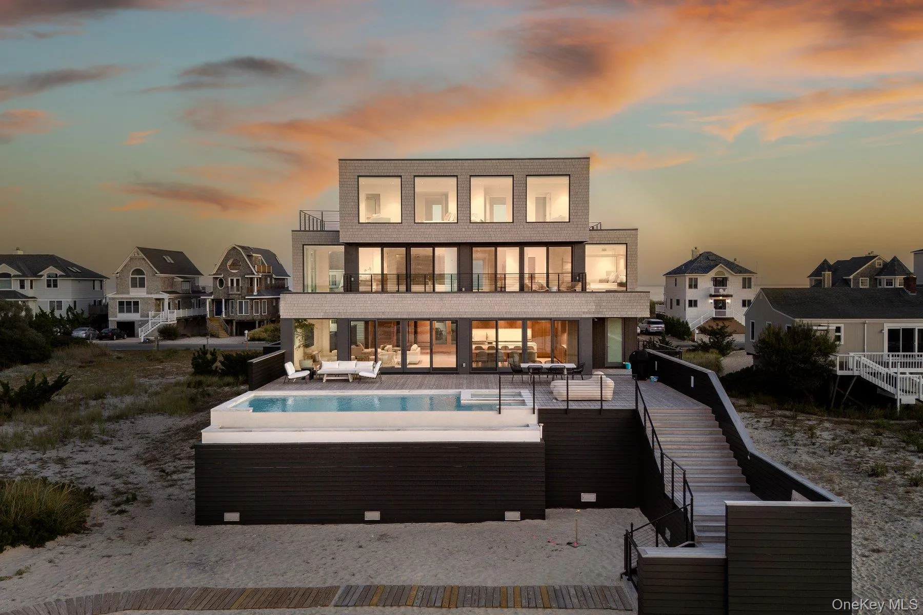 Back of house at dusk featuring stairway, a patio, a balcony, and a residential view Back of house at dusk featuring stairway, a patio, a balcony, and a residential view