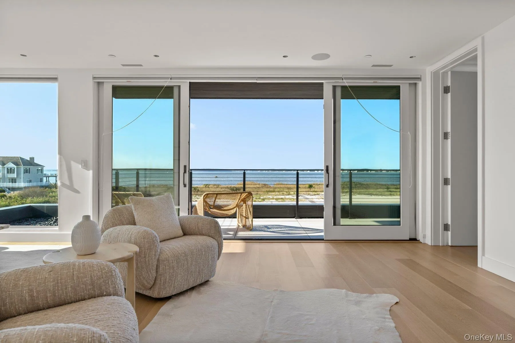 Doorway featuring wood finished floors, a water view, and expansive windows Doorway featuring wood finished floors, a water view, and expansive windows