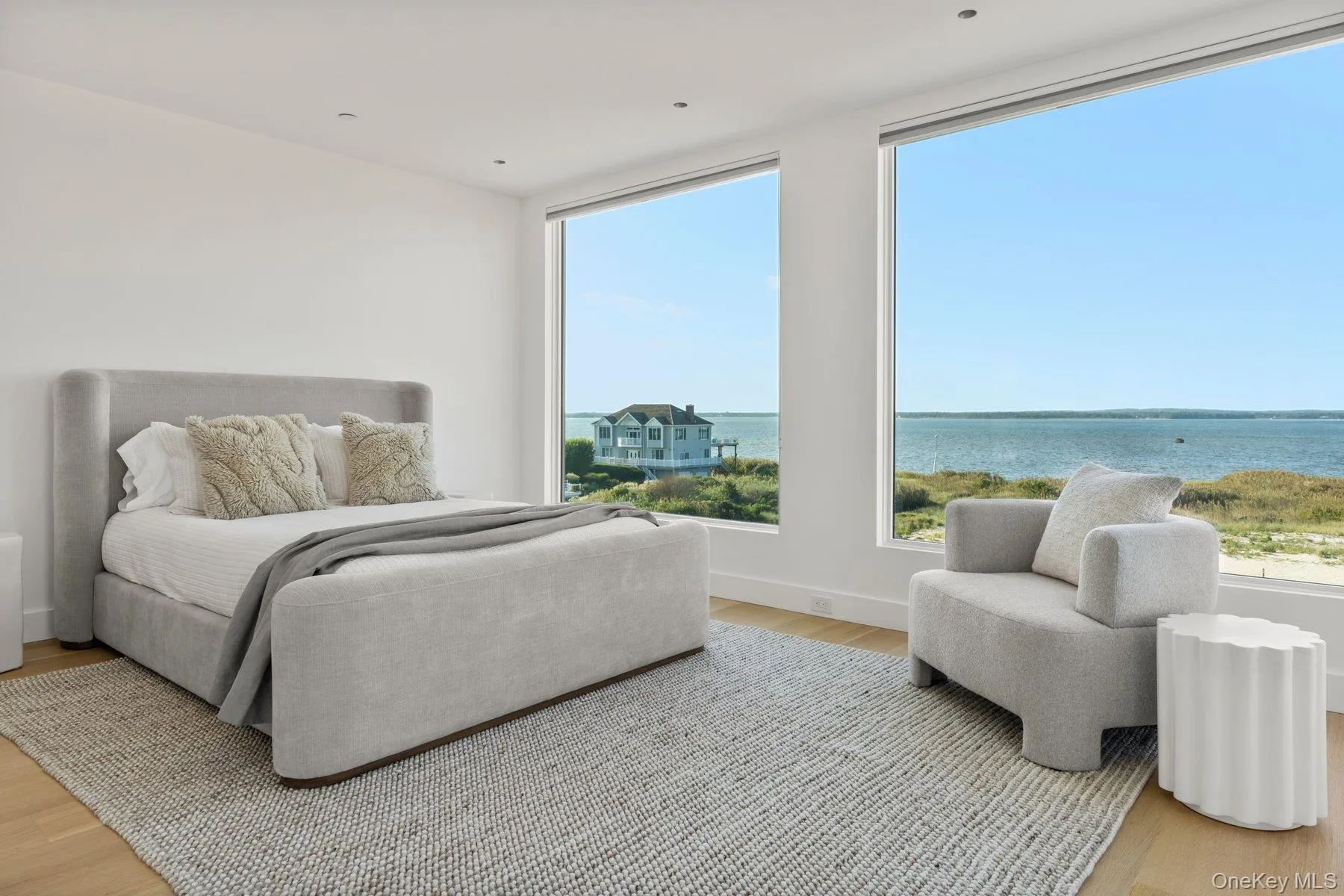 Bedroom with light wood finished floors and a water view Bedroom with light wood finished floors and a water view