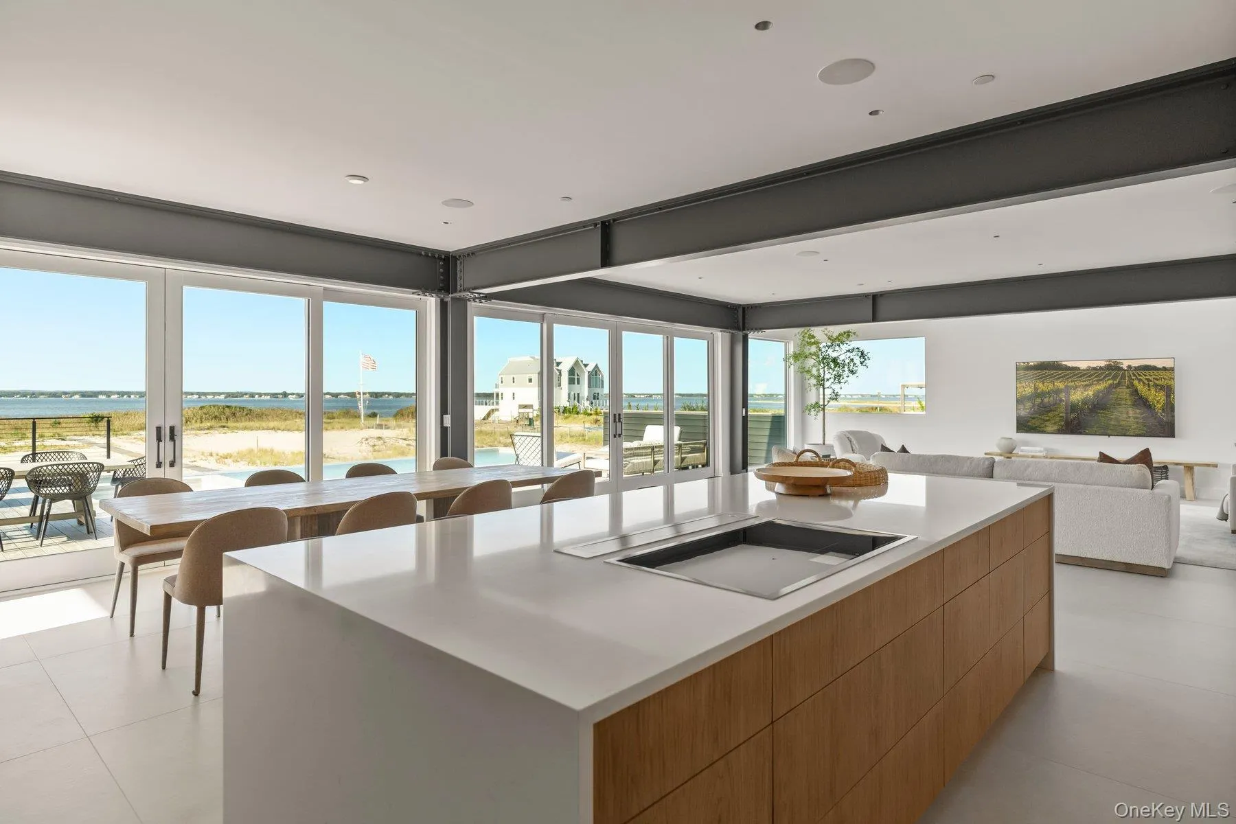 Kitchen featuring modern cabinets, a large island, open floor plan, black electric stovetop, and light tile patterned flooring Kitchen featuring modern cabinets, a large island, open floor plan, black electric stovetop, and light tile patterned flooring