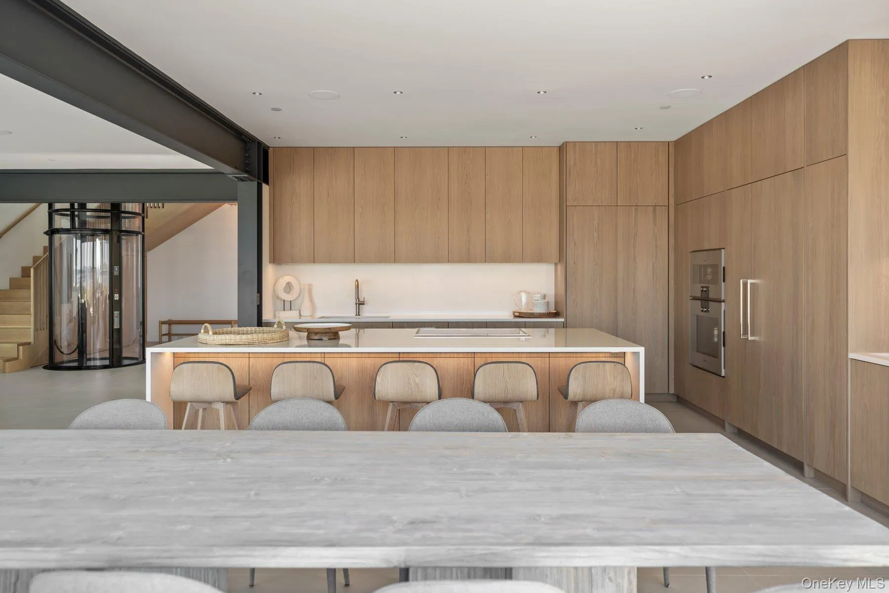 Kitchen featuring modern cabinets, a kitchen island, a breakfast bar, and light stone countertops Kitchen featuring modern cabinets, a kitchen island, a breakfast bar, and light stone countertops
