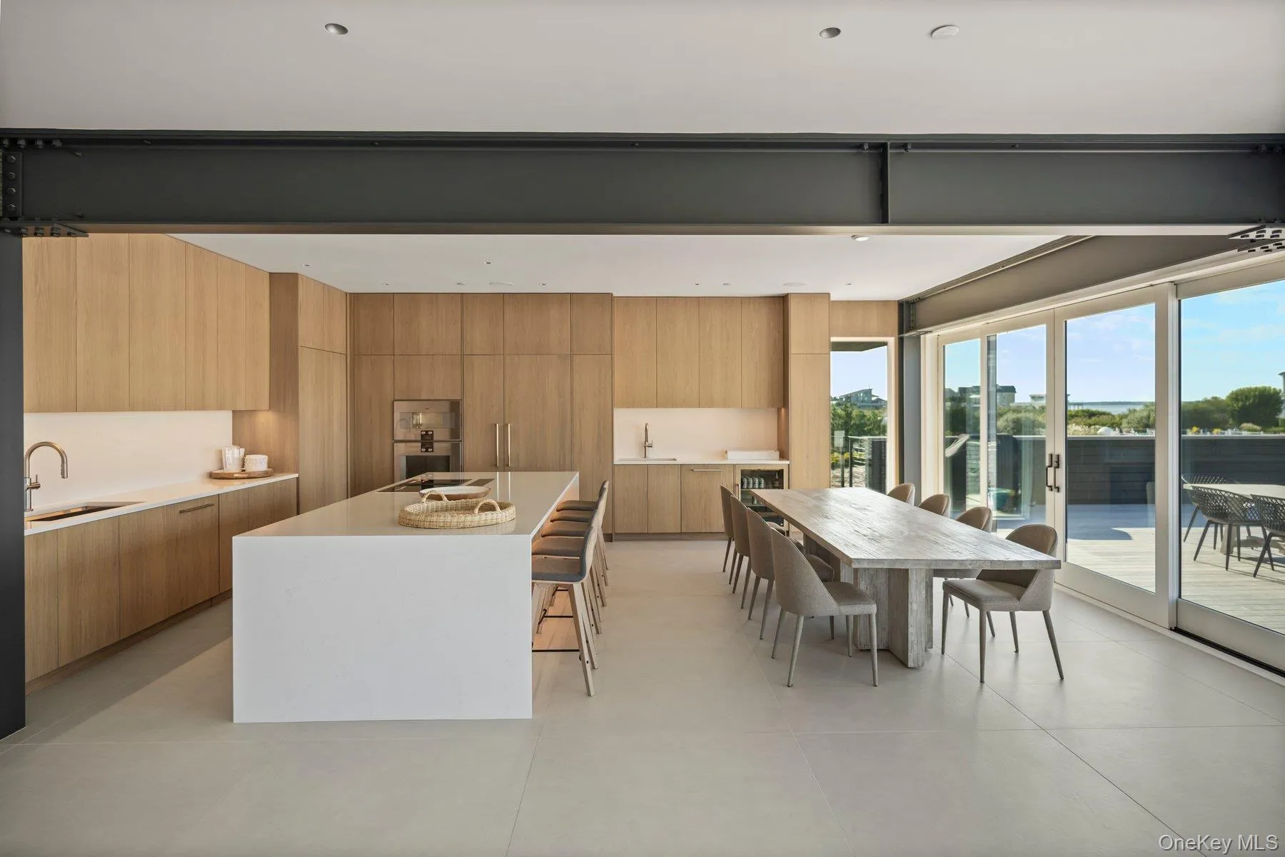 Kitchen with modern cabinets, a kitchen breakfast bar, a kitchen island, and light stone countertops Kitchen with modern cabinets, a kitchen breakfast bar, a kitchen island, and light stone countertops