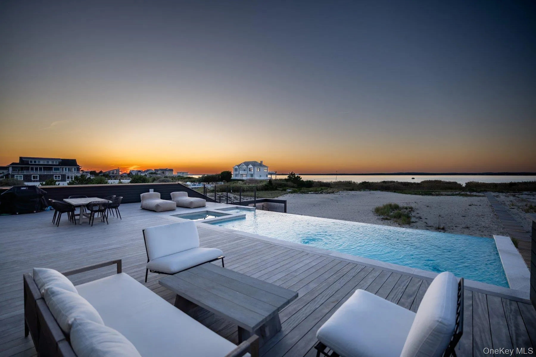 View of pool with an infinity pool, outdoor dining space, a jacuzzi, an outdoor living space, and a water view View of pool with an infinity pool, outdoor dining space, a jacuzzi, an outdoor living space, and a water view