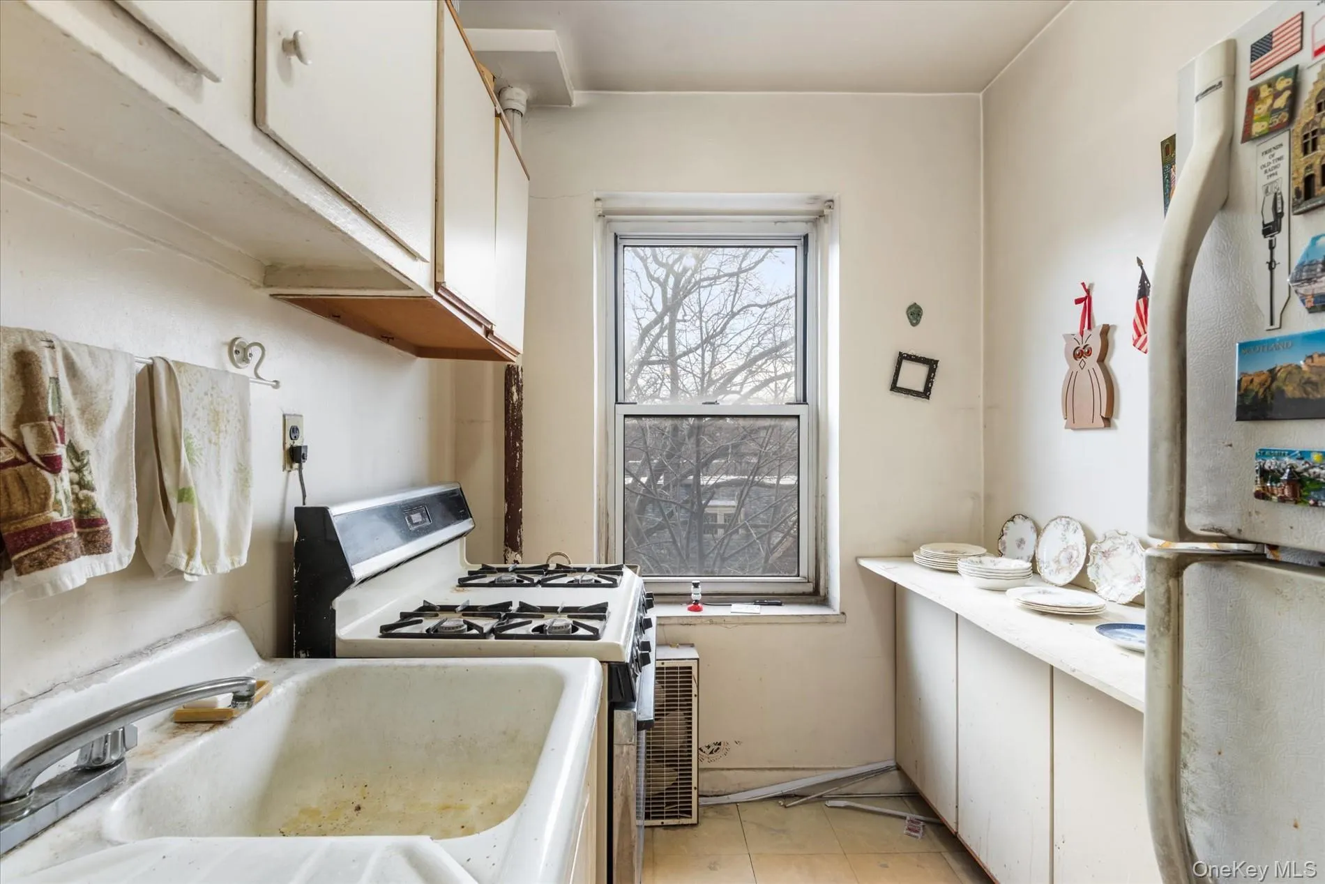 Kitchen featuring white appliances, white cabinets, a sink, and light countertops Kitchen featuring white appliances, white cabinets, a sink, and light countertops
