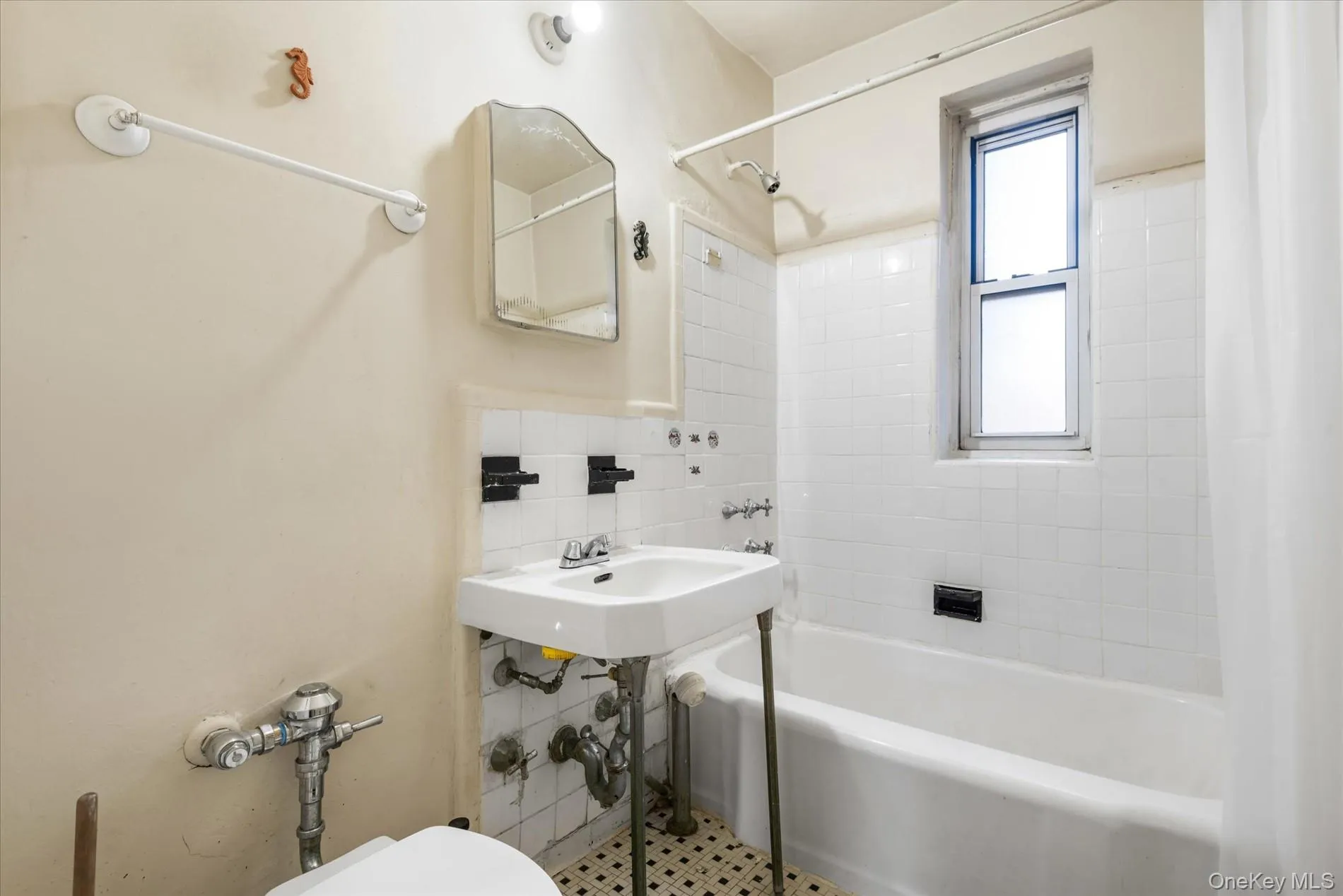 Full bathroom featuring shower / tub combo, a sink, tile walls, and toilet Full bathroom featuring shower / tub combo, a sink, tile walls, and toilet