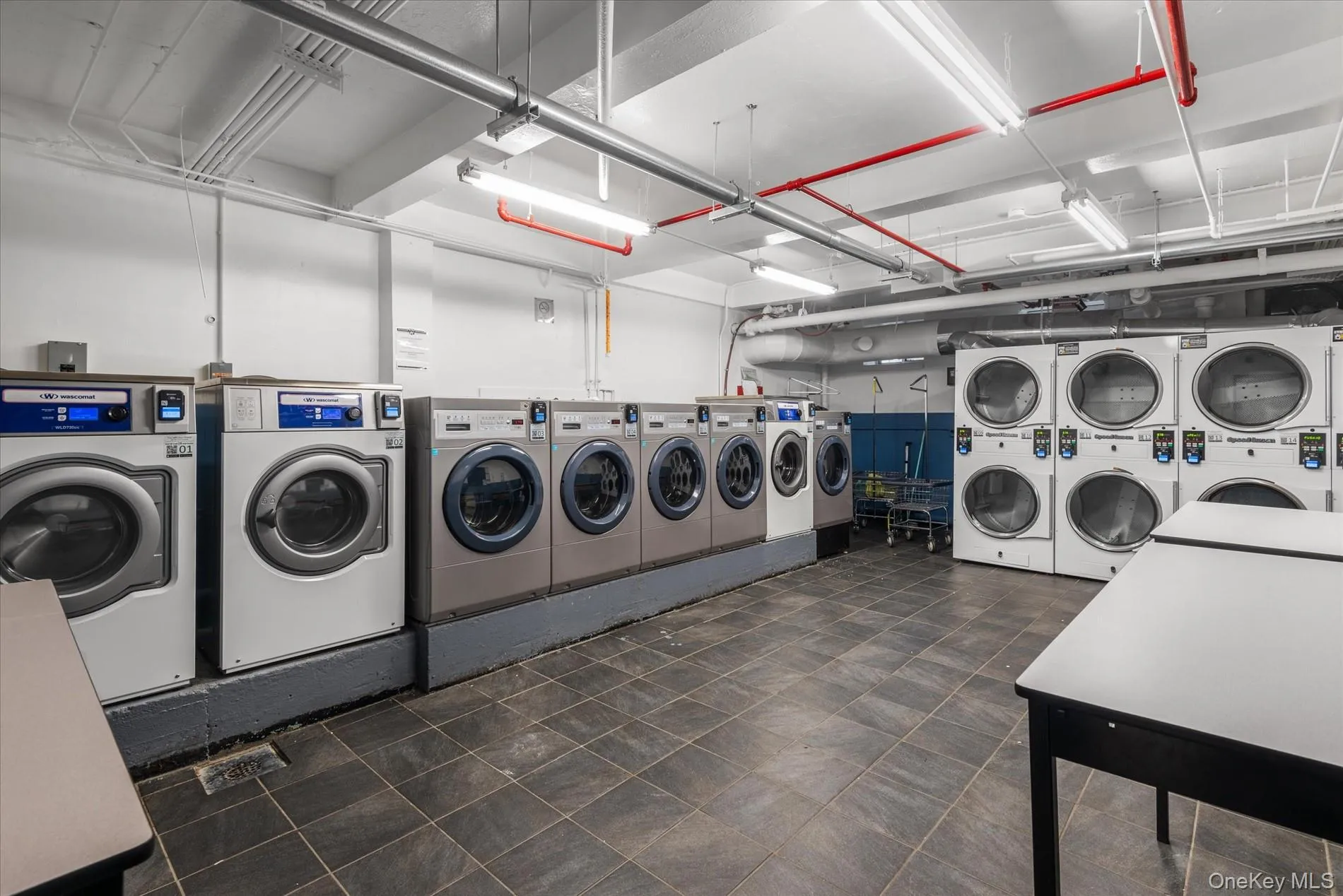 Shared laundry area featuring a garage, stacked washer and dryer, and separate washer and dryer Shared laundry area featuring a garage, stacked washer and dryer, and separate washer and dryer