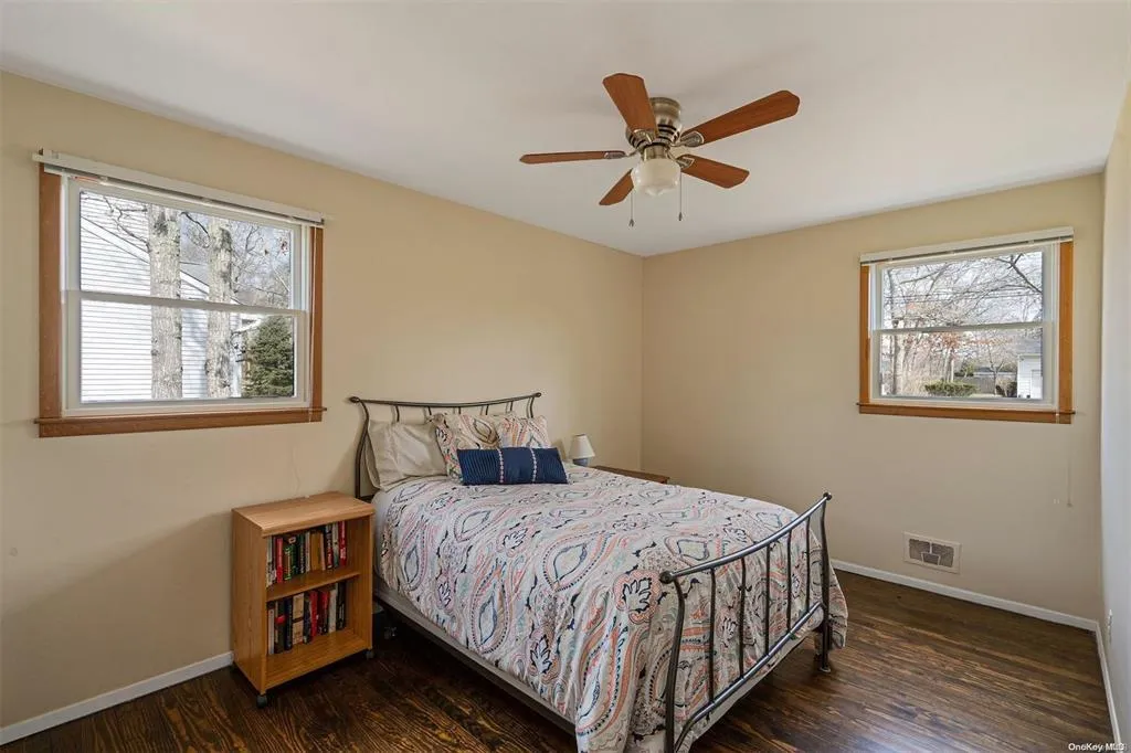 Bedroom featuring ceiling fan, wood finished floors, visible vents, and baseboards Bedroom featuring ceiling fan, wood finished floors, visible vents, and baseboards