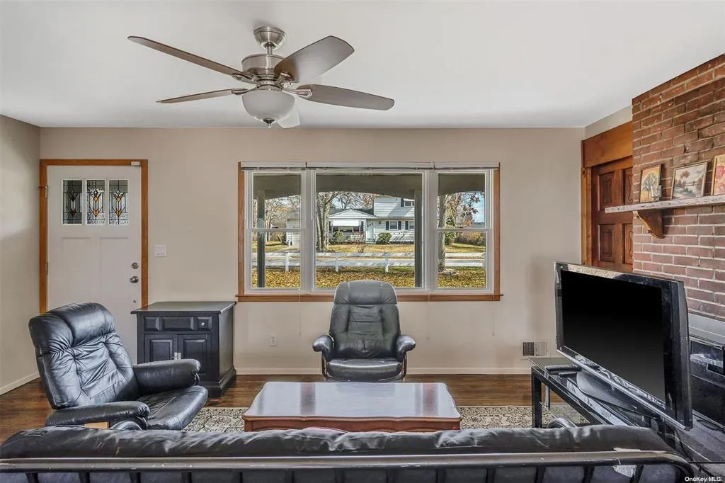 Living area with ceiling fan, wood finished floors, and baseboards Living area with ceiling fan, wood finished floors, and baseboards