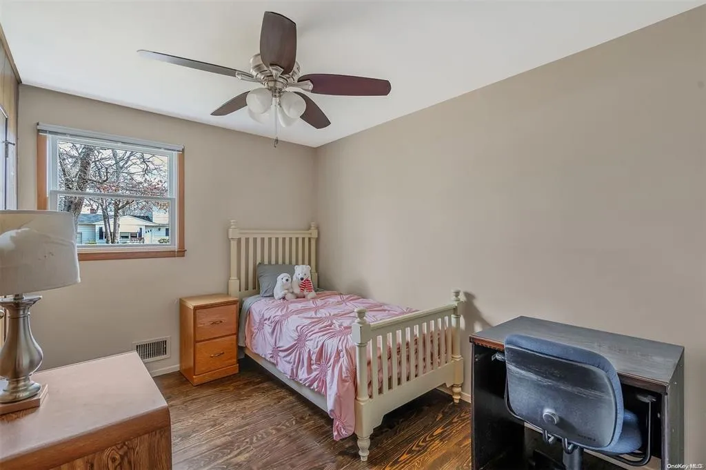 Bedroom with baseboards, wood finished floors, visible vents, and a ceiling fan Bedroom with baseboards, wood finished floors, visible vents, and a ceiling fan