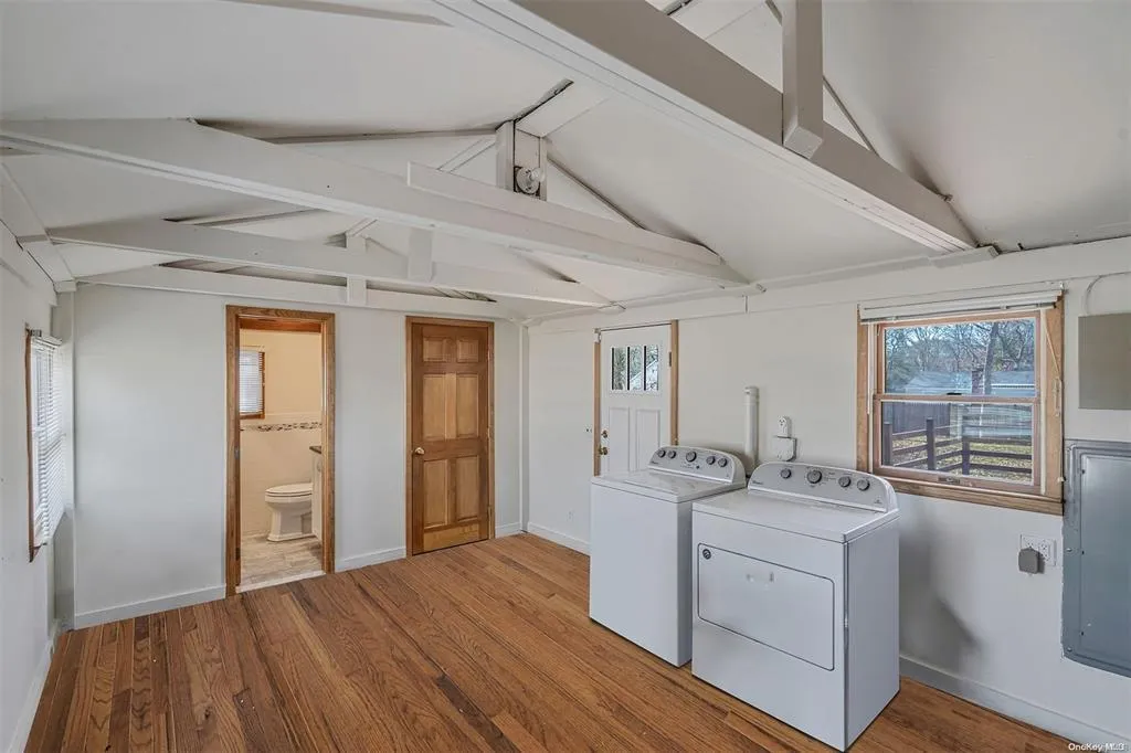 Washroom featuring laundry area, independent washer and dryer, baseboards, and wood finished floors Washroom featuring laundry area, independent washer and dryer, baseboards, and wood finished floors
