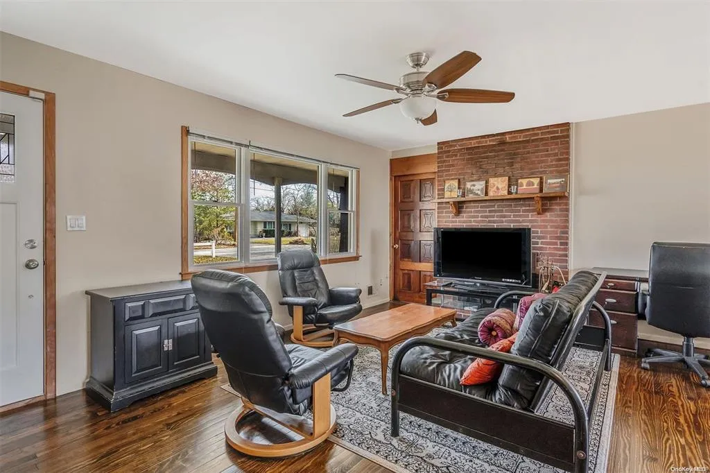 Living area with a ceiling fan and wood finished floors Living area with a ceiling fan and wood finished floors