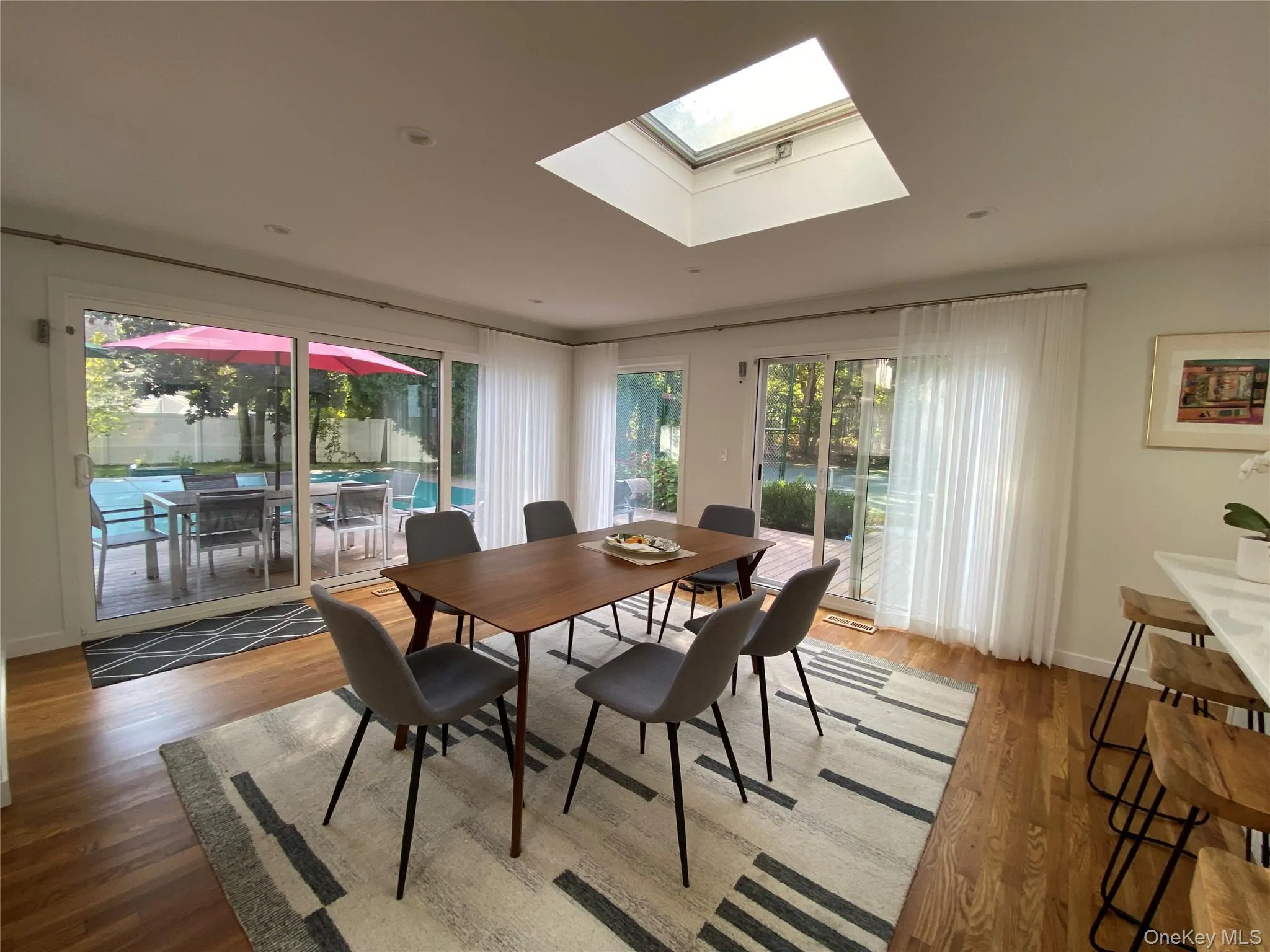 Dining area featuring a skylight,  and wood finished floors Dining area featuring a skylight,  and wood finished floors