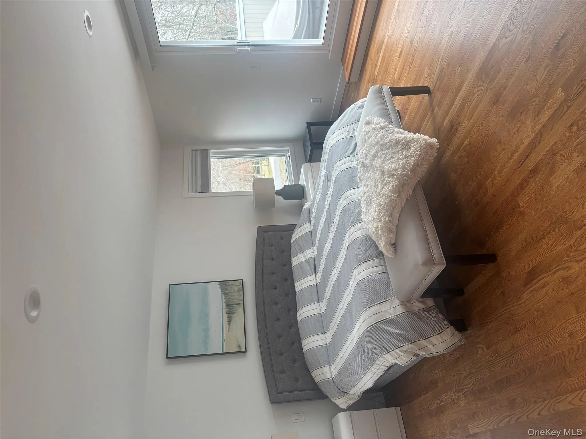 Bedroom featuring access to outside, baseboards, multiple windows, and wood finished floors Bedroom featuring access to outside, baseboards, multiple windows, and wood finished floors