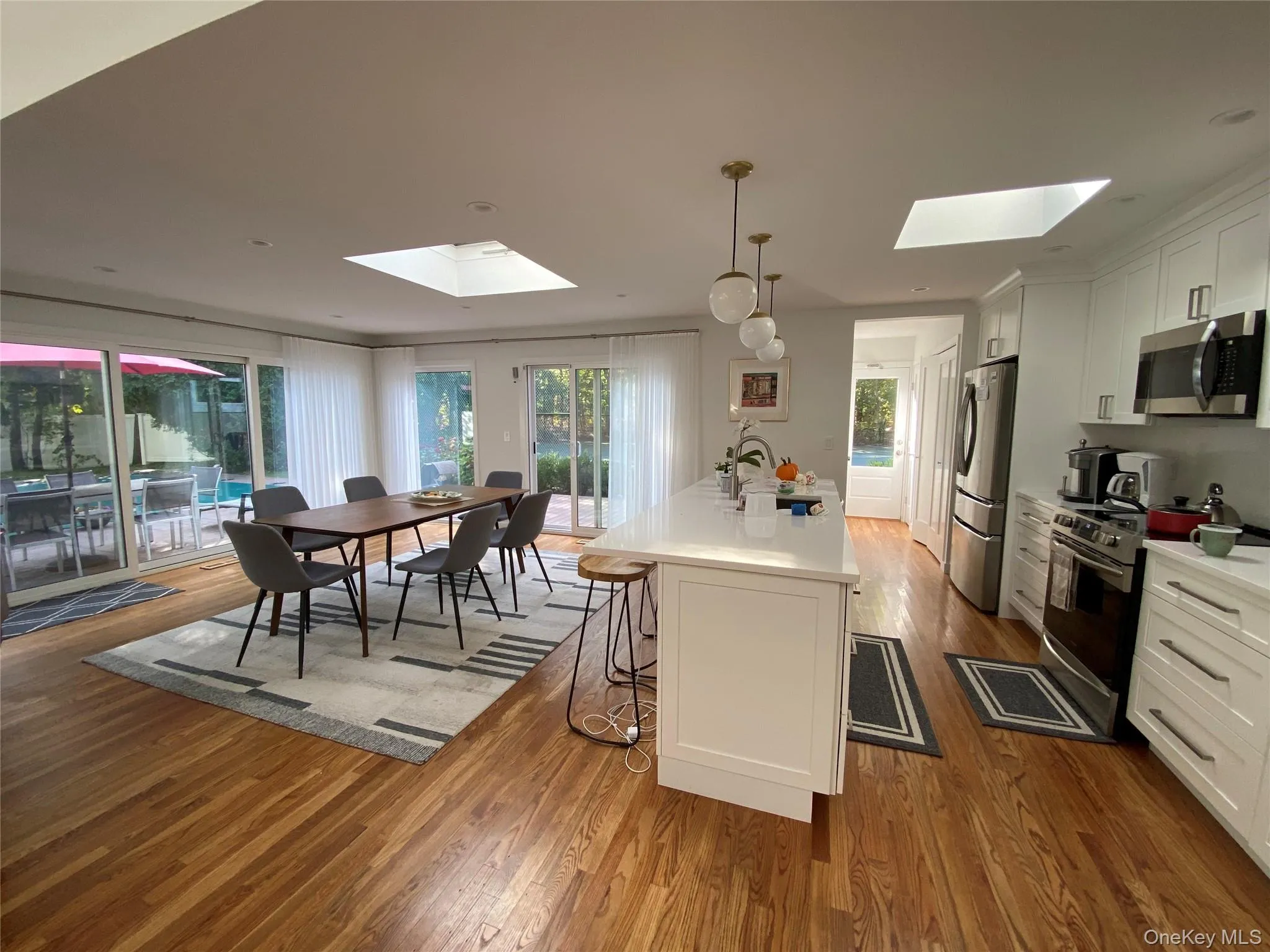 Kitchen featuring all new appliances, a skylight, and white cabinetry Kitchen featuring all new appliances, a skylight, and white cabinetry