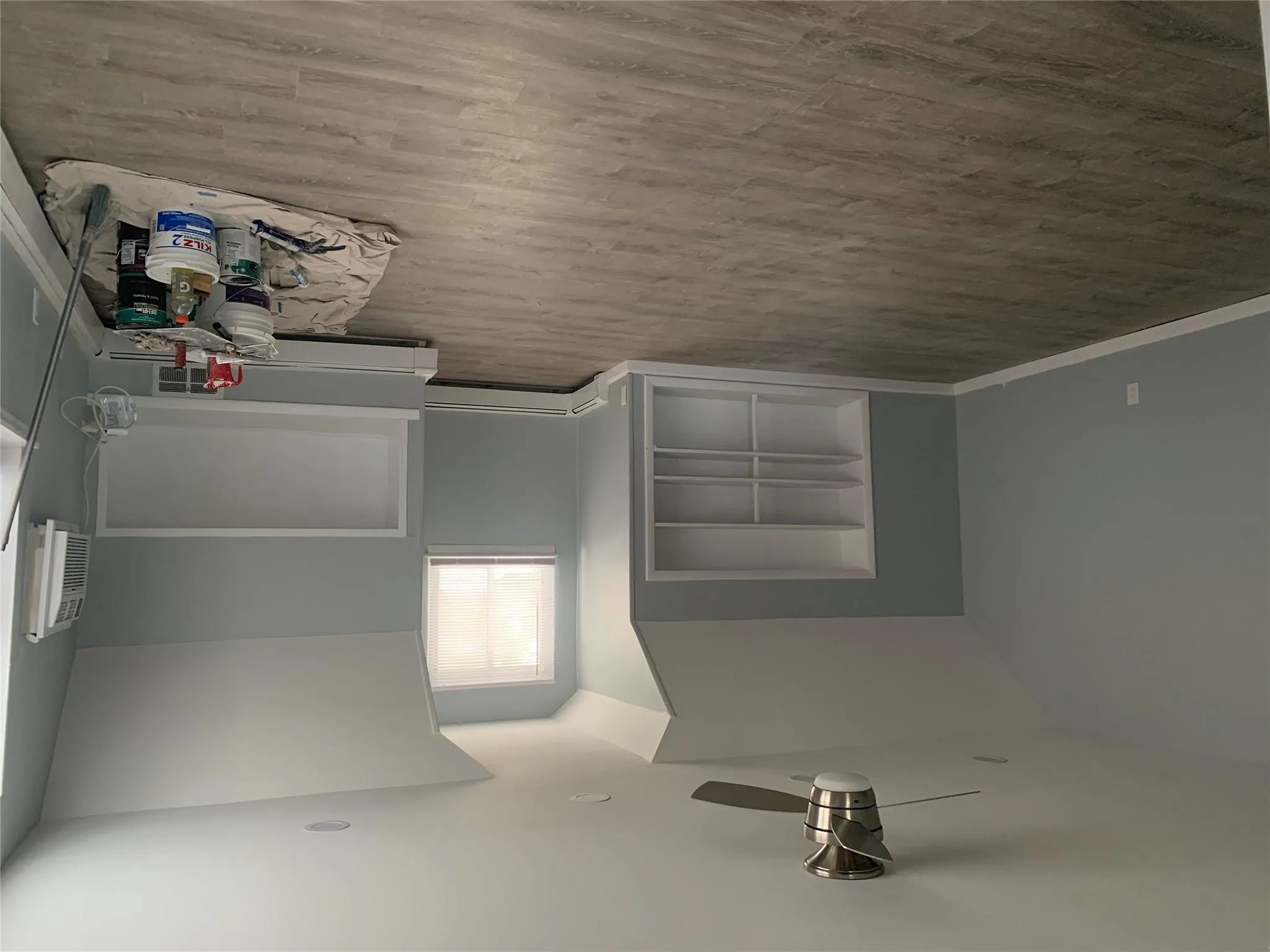 Bonus room featuring built in shelves, vaulted ceiling, baseboard heating, a ceiling fan, and wood finished floors Bonus room featuring built in shelves, vaulted ceiling, baseboard heating, a ceiling fan, and wood finished floors