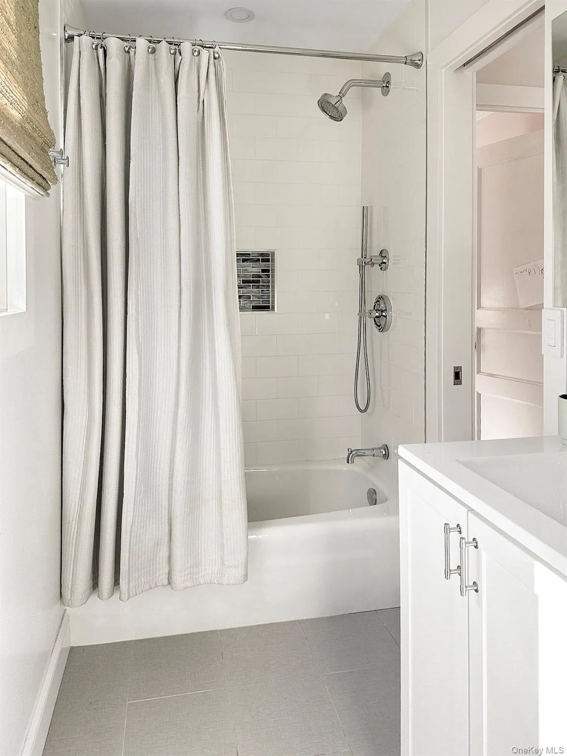 Full bath with shower / tub combo, vanity, and tile patterned floors Full bath with shower / tub combo, vanity, and tile patterned floors