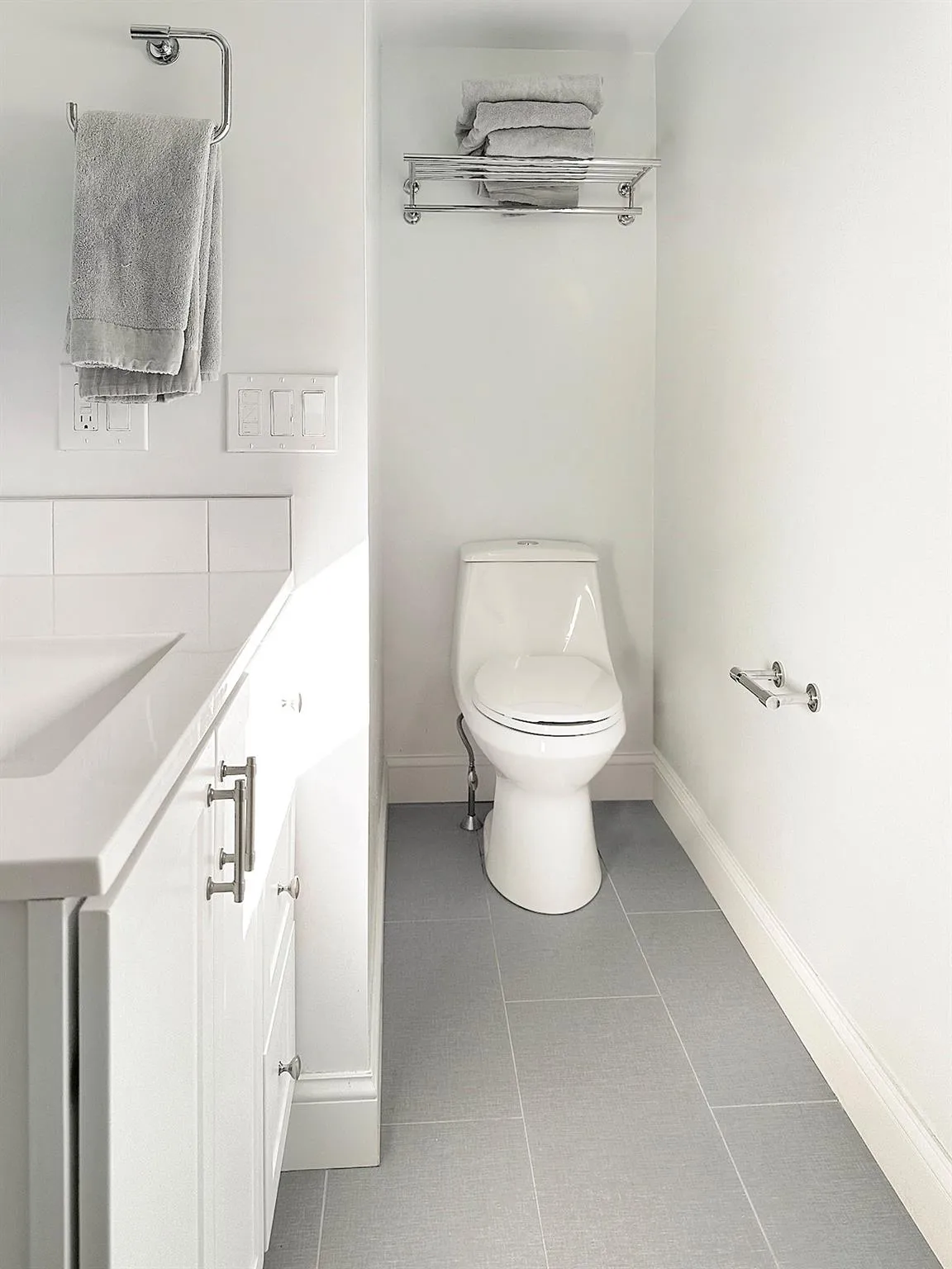 Half bath featuring toilet, tile patterned flooring, baseboards, and a sink Half bath featuring toilet, tile patterned flooring, baseboards, and a sink