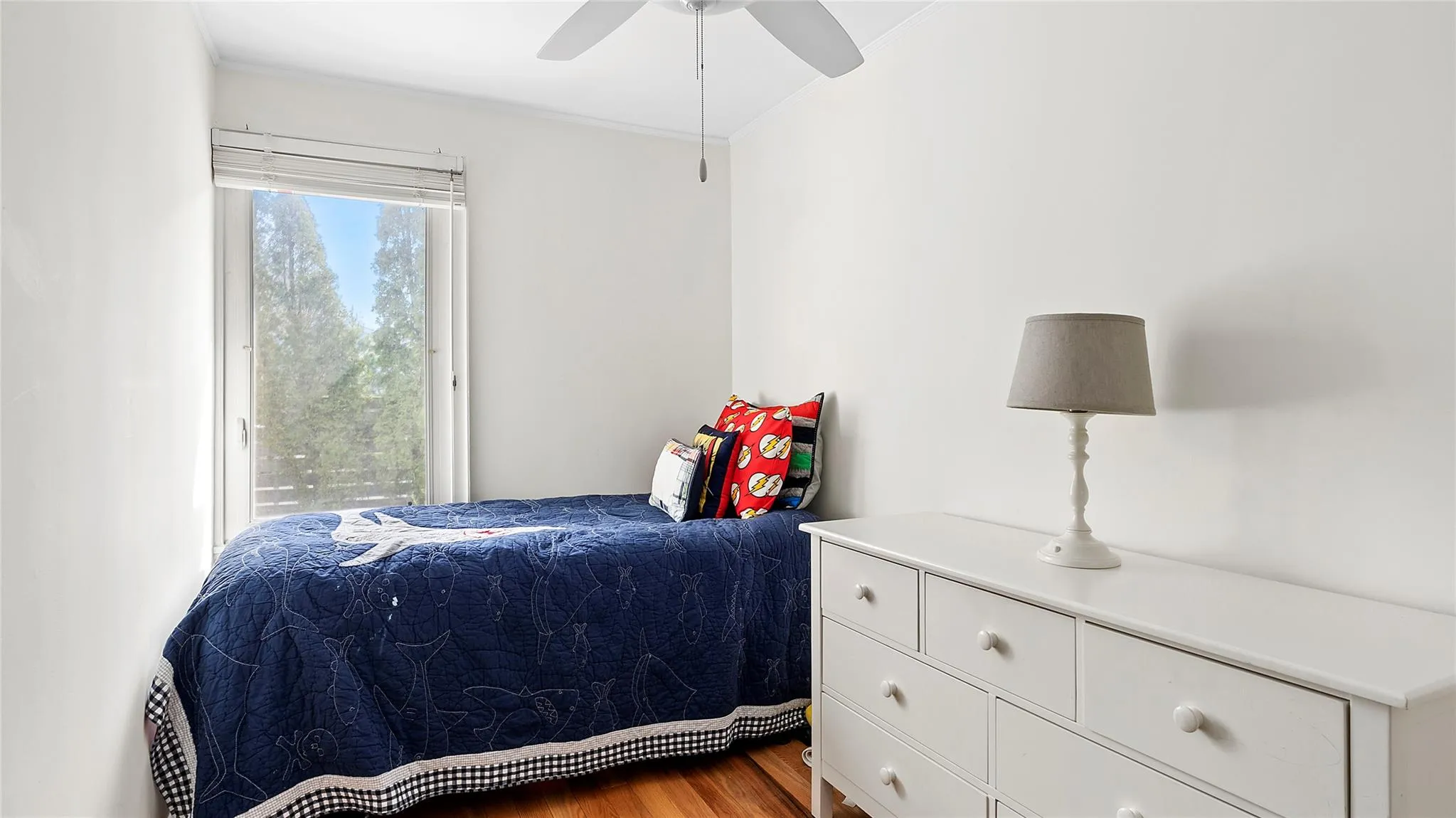 Bedroom featuring a ceiling fan and wood finished floors Bedroom featuring a ceiling fan and wood finished floors