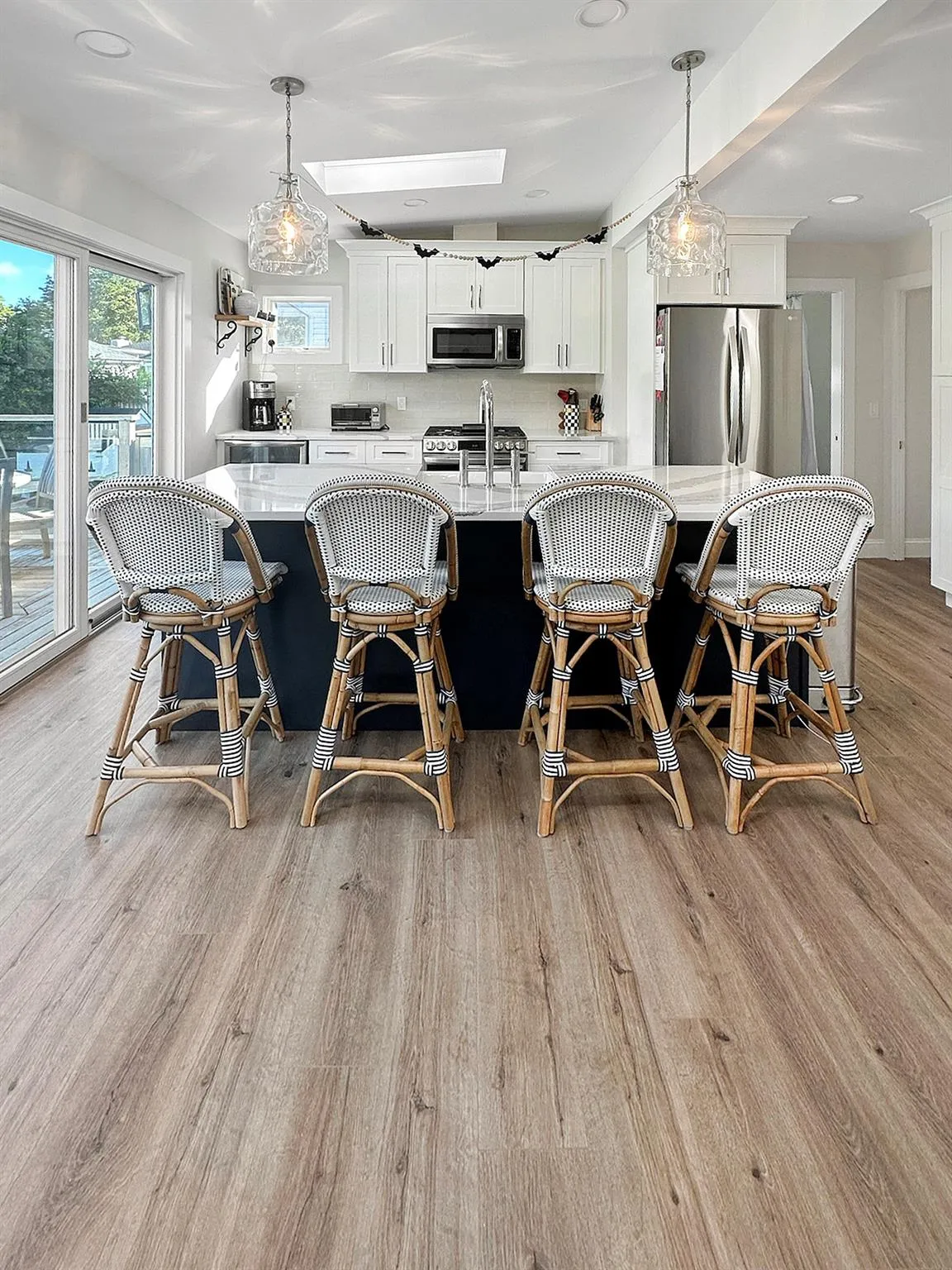 Kitchen featuring appliances with stainless steel finishes, light wood-type flooring, light countertops, and a sink Kitchen featuring appliances with stainless steel finishes, light wood-type flooring, light countertops, and a sink