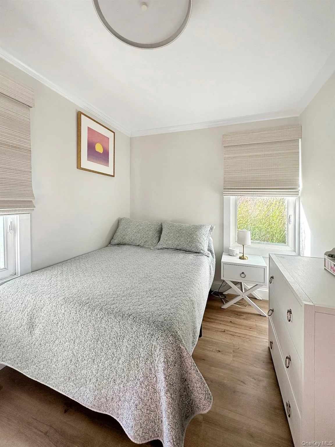 Bedroom featuring ornamental molding and wood finished floors Bedroom featuring ornamental molding and wood finished floors