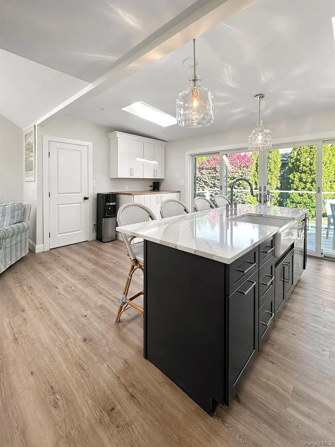 Kitchen with plenty of natural light, light wood-type flooring, a sink, and white cabinetry Kitchen with plenty of natural light, light wood-type flooring, a sink, and white cabinetry